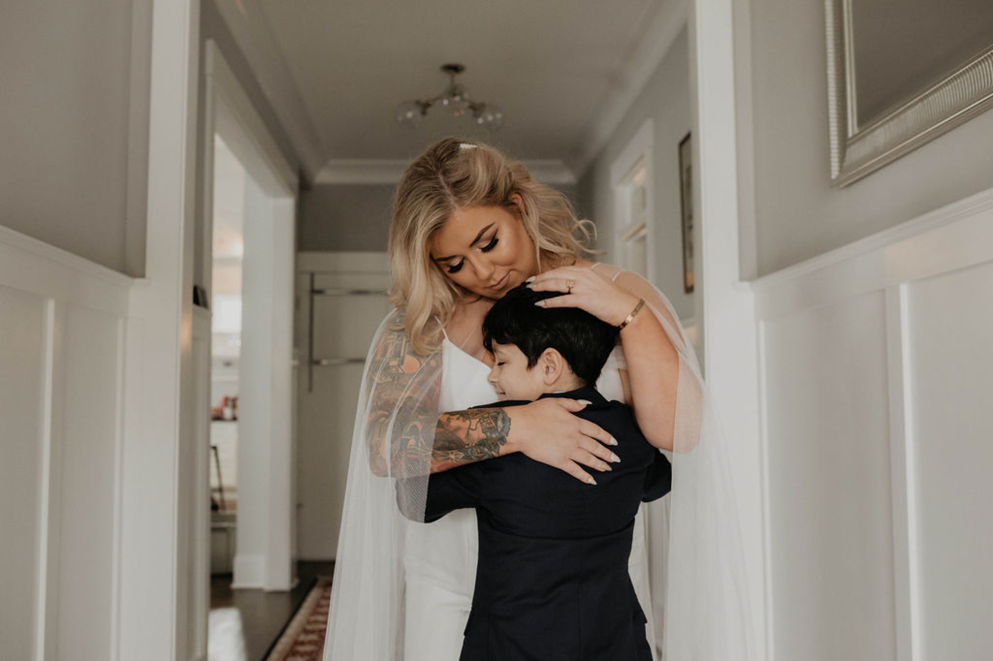 Bride in an Allure Bridals Mermaid Gown -Hugging her ring bearer - Matt Smarsh and Johanna Dye - suites by the black tux - Raleigh North Carolina Urban Edgy Downtown Wedding - suits by the black tux