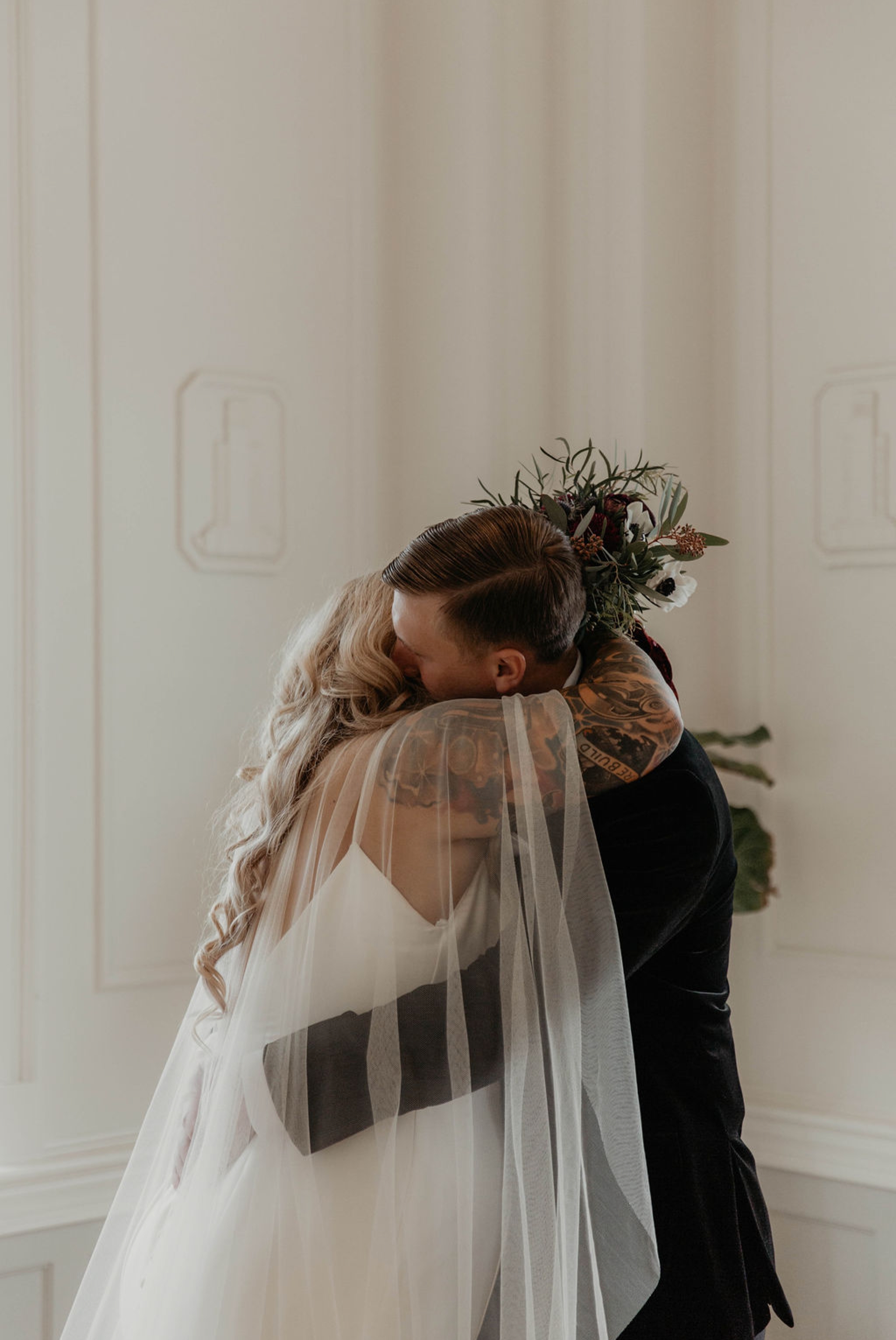 First look between bride and groom - wedding couple hugging each other for the first time - First look between bride and groom at the cannon room - Bride in an Allure Bridals Mermaid Gown - Matt Smarsh and Johanna Dye - suites by the black tux - Raleigh North Carolina Urban Edgy Downtown Wedding - suits by the black tux