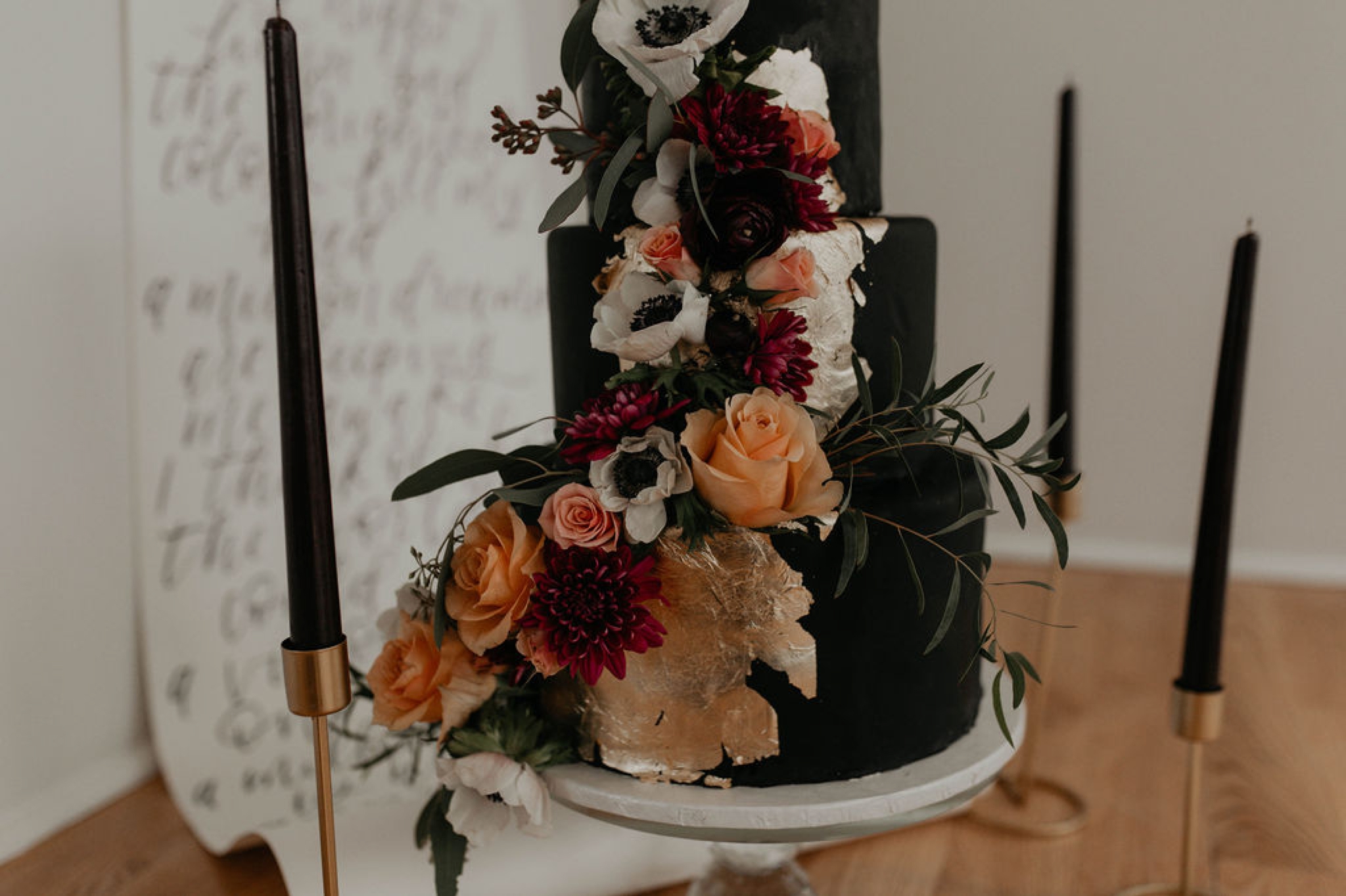 Black wedding cake with gold and flower accents by sugar euphoria at the Glassbox at 230 - til death cake topper - Matt Smarsh and Johanna Dye - suites by the black tux - Raleigh North Carolina Urban Downtown Wedding