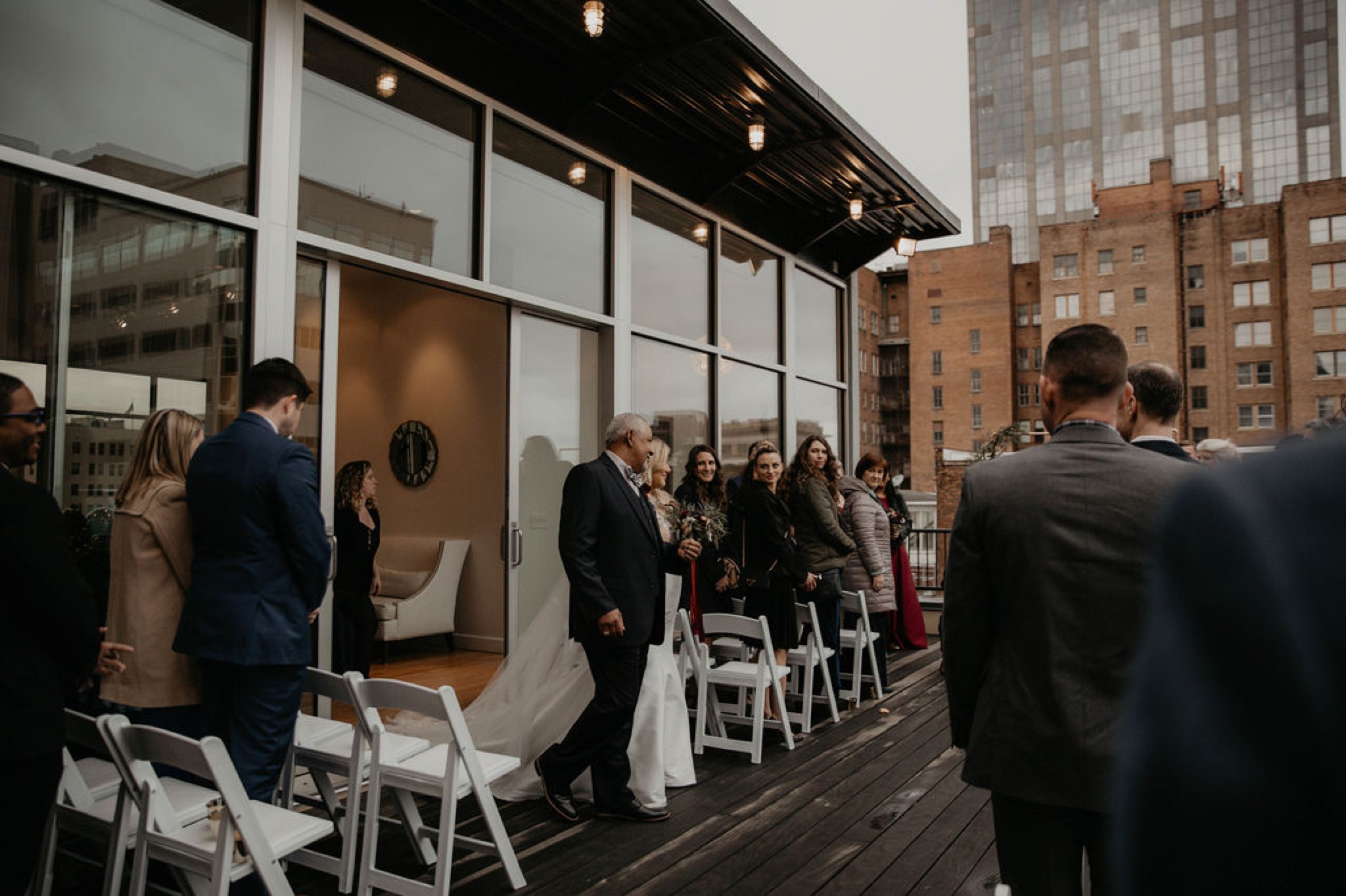 Father and Bride walking down the aisle - Wedding Ceremony on a rooftop terrace with the skyline in the background - Matt Smarsh and Johanna Dye - Raleigh North Carolina Urban Downtown Wedding at the Glass Box at 230