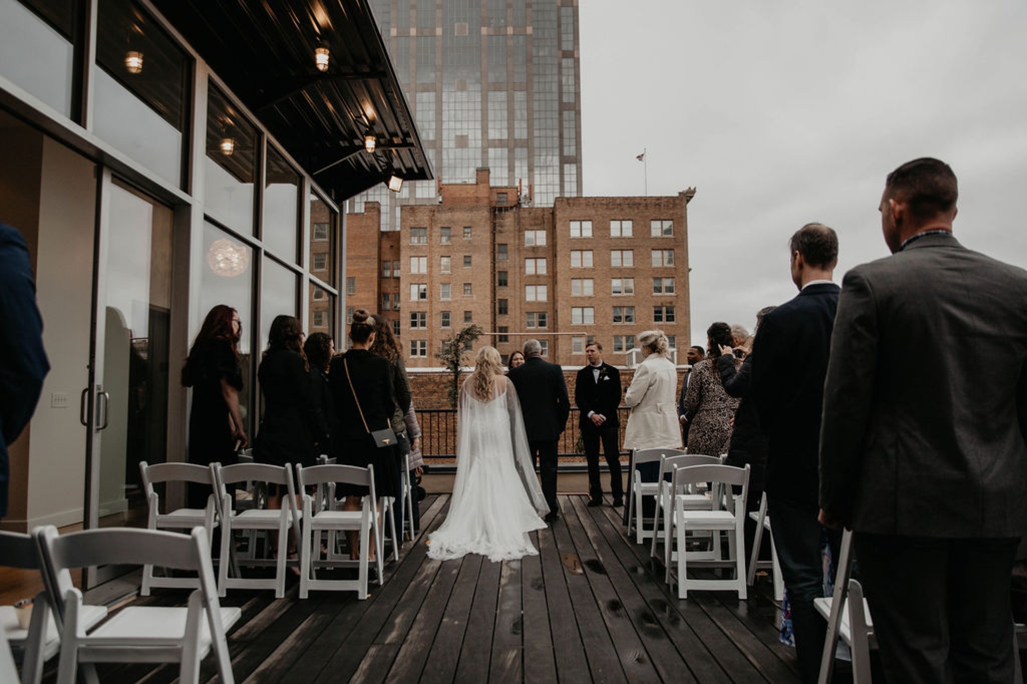 Father and Bride walking down the aisle - Wedding Ceremony on a rooftop terrace with the skyline in the background - Matt Smarsh and Johanna Dye - Raleigh North Carolina Urban Downtown Wedding at the Glass Box at 230