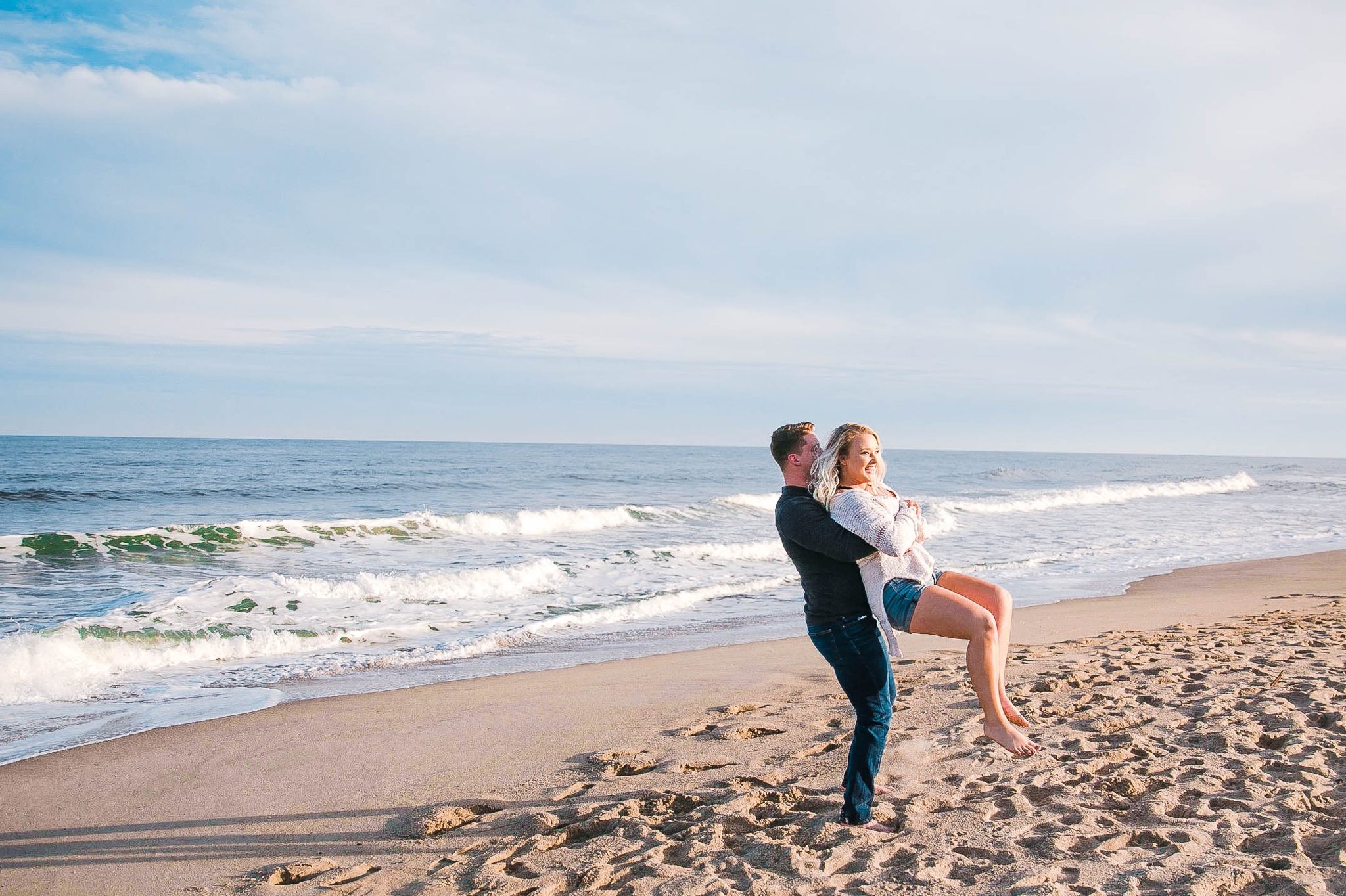  fiance being playful on the beach - girl wearing ripped jeans shorts and a white free people sweater - Casual Beach Engagement Photography Session - Honolulu Oahu Hawaii Wedding Photographer - Johanna Dye 