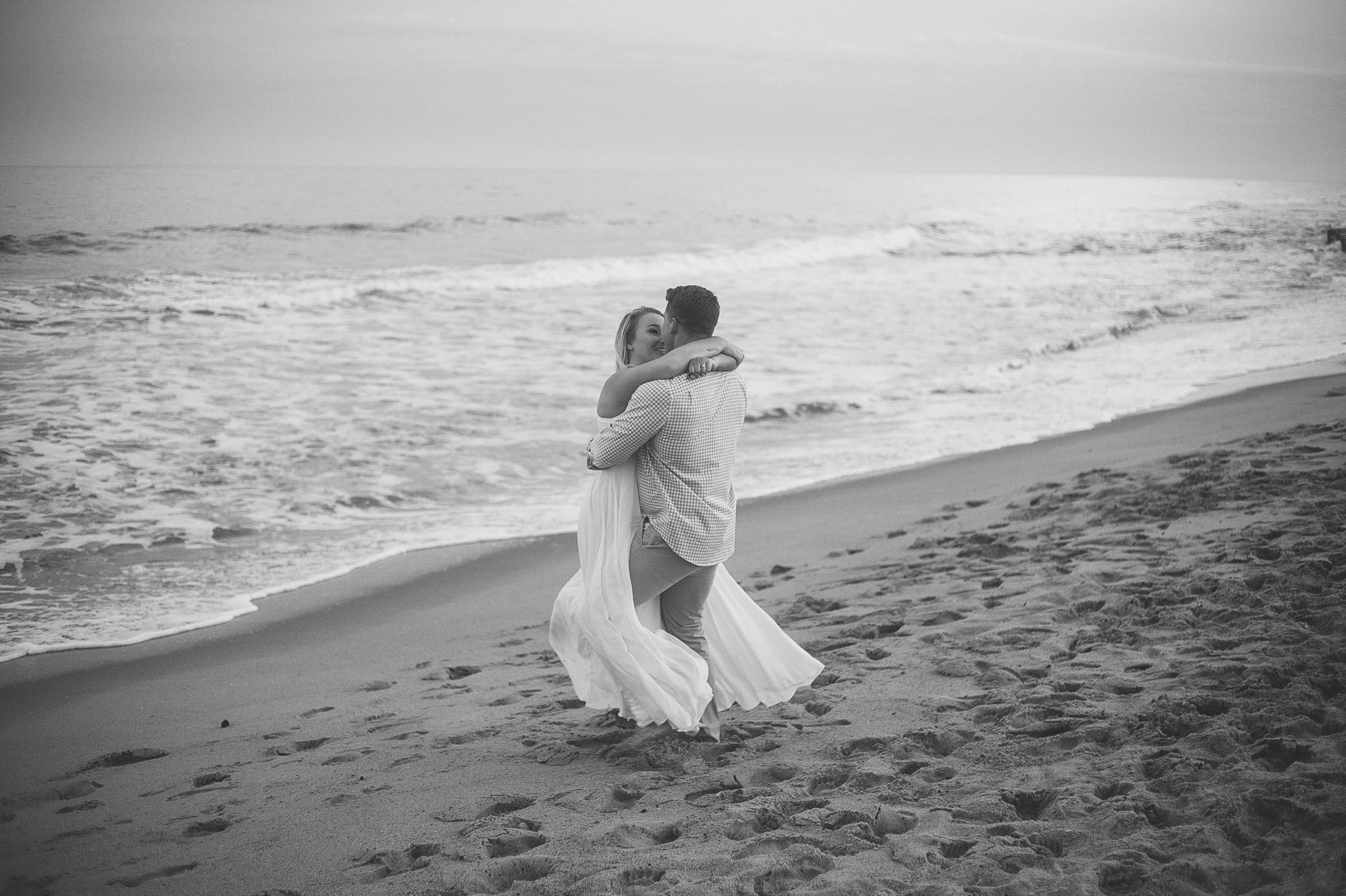  Black and White Romantic Engagement Photography Session at the beach during sunset - guy is kissing his fiance - girl is wearing a white flowy maxi dress from lulus - Honolulu Oahu Hawaii Wedding Photographer - Johanna Dye 