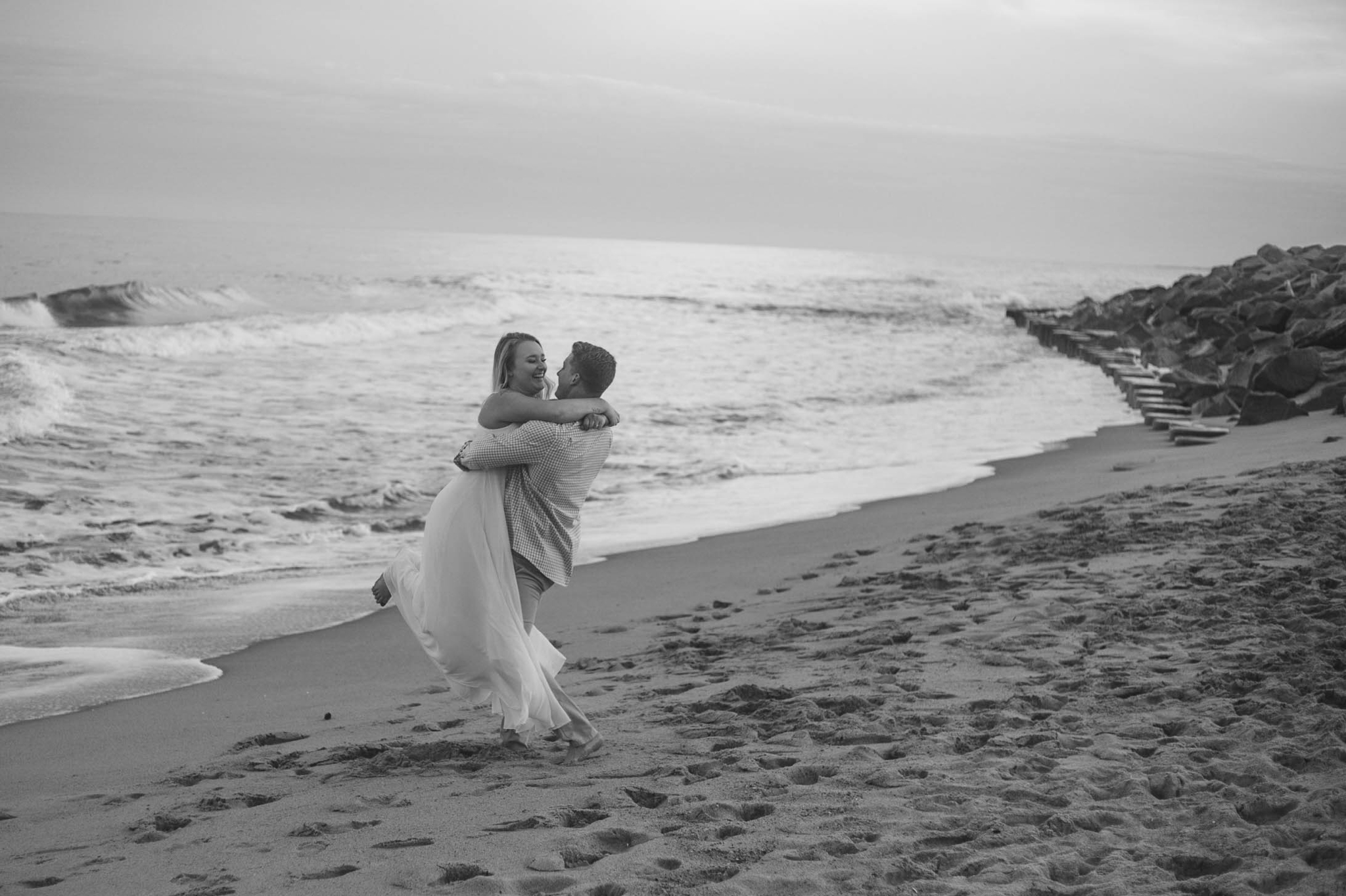  Black and White Romantic Engagement Photography Session at the beach during sunset - guy is kissing his fiance - girl is wearing a white flowy maxi dress from lulus - Honolulu Oahu Hawaii Wedding Photographer - Johanna Dye 