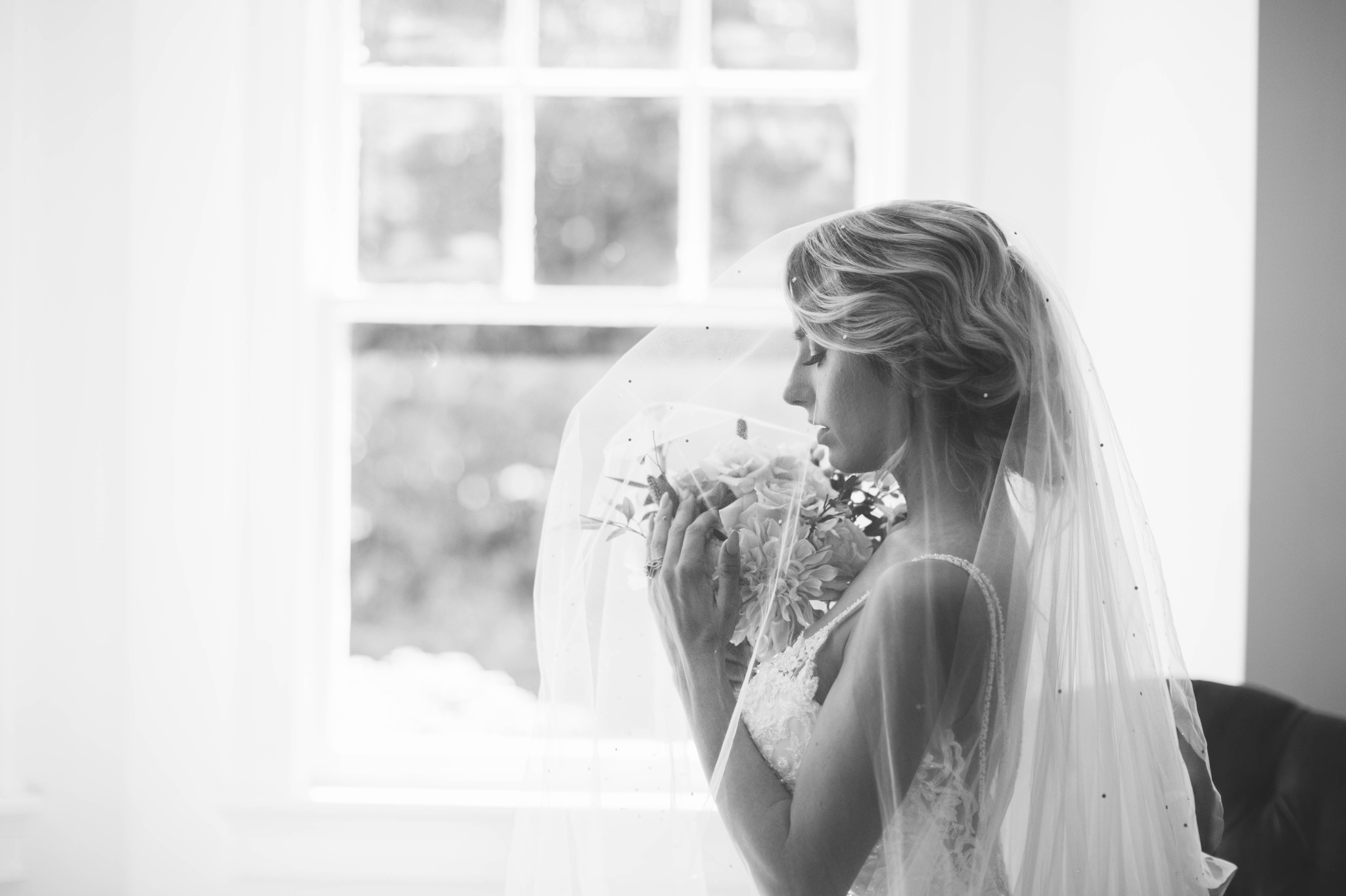  black and white Indoor Natural Light Bridal Portraits by a window with a white backdrop - classic bride with soft drop veil over her face -  wedding gown by Stella York - Honolulu, Oahu, Hawaii Wedding Photographer 