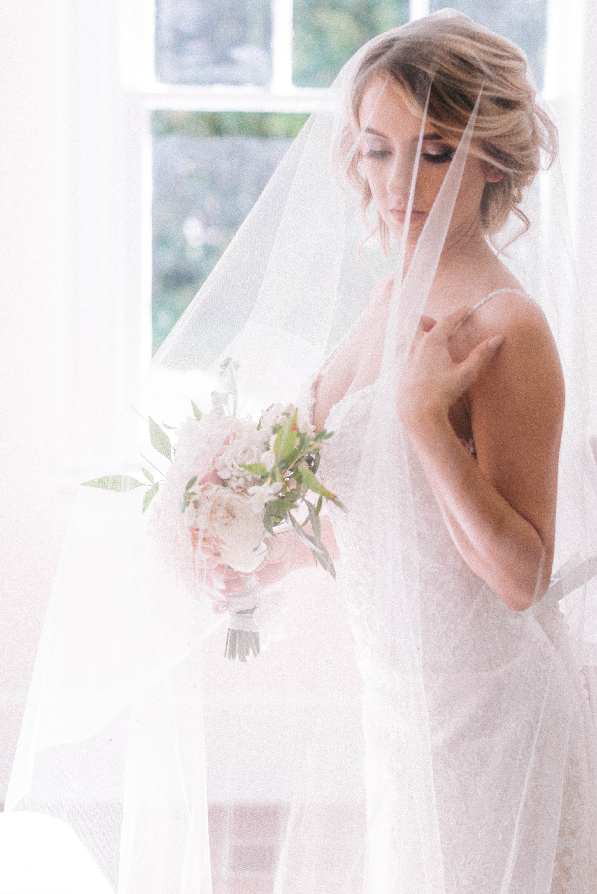  black and white Indoor Natural Light Bridal Portraits by a window with a white backdrop - classic bride with soft drop veil over her face - wedding gown by Stella York - Honolulu, Oahu, Hawaii Wedding Photographer 