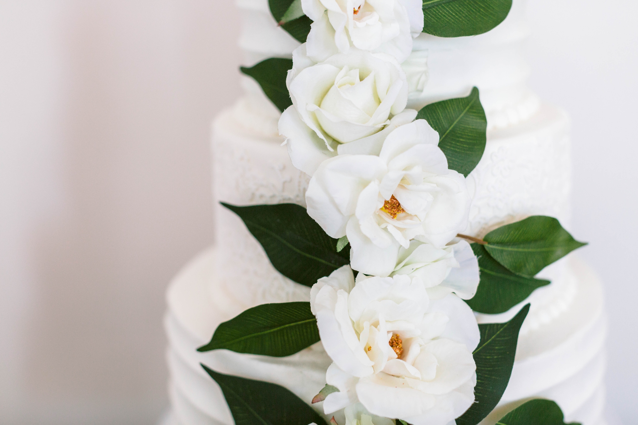  wedding cake table on an all white antique dresser with an all white cake decorated with greenery - luxury cake table inspiration - honolulu oahu hawaii wedding photographer - johanna dye photography 