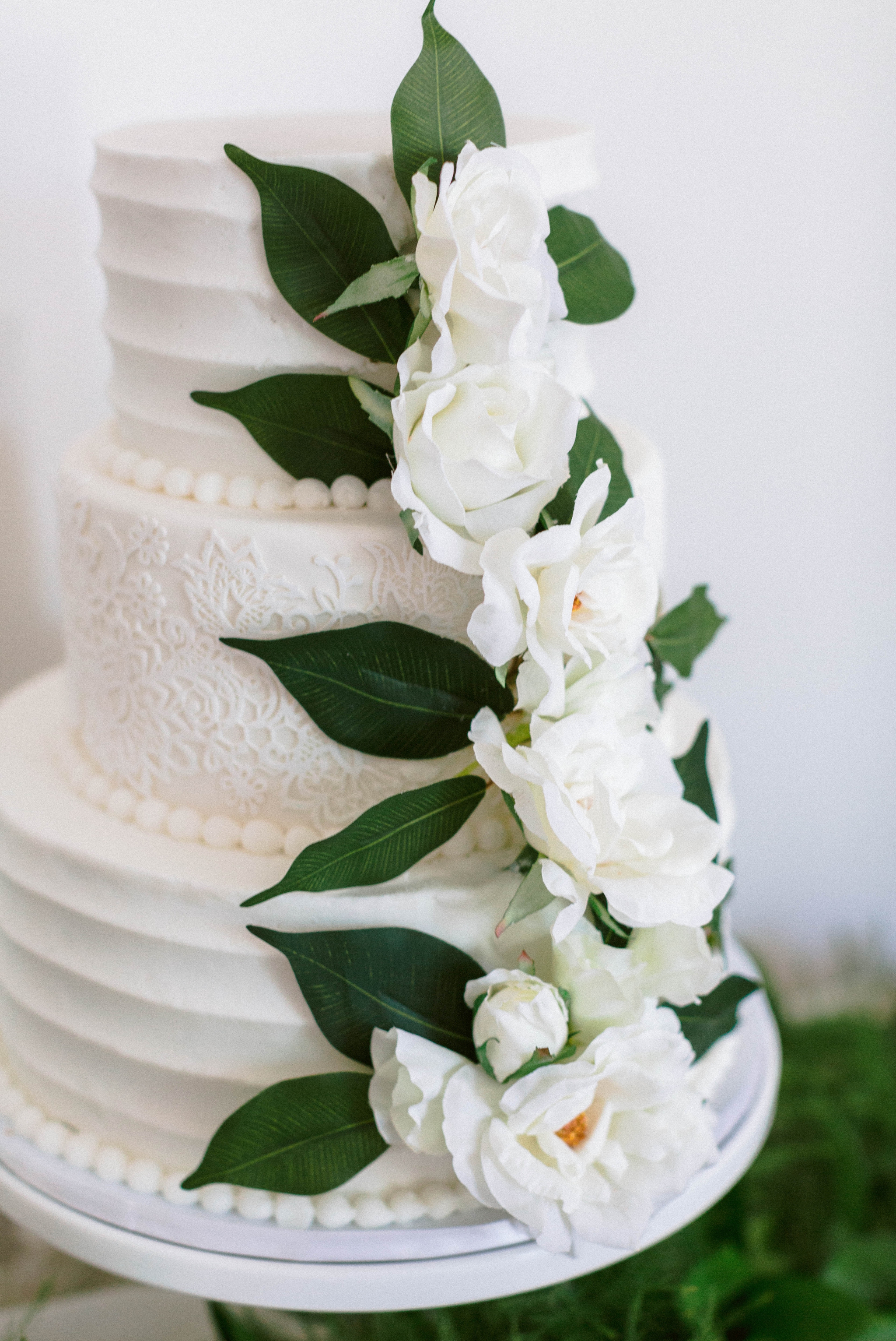  wedding  cake table on an all white antique dresser with an all white cake decorated with greenery - luxury cake table inspiration - honolulu oahu hawaii wedding photographer - johanna dye photography 