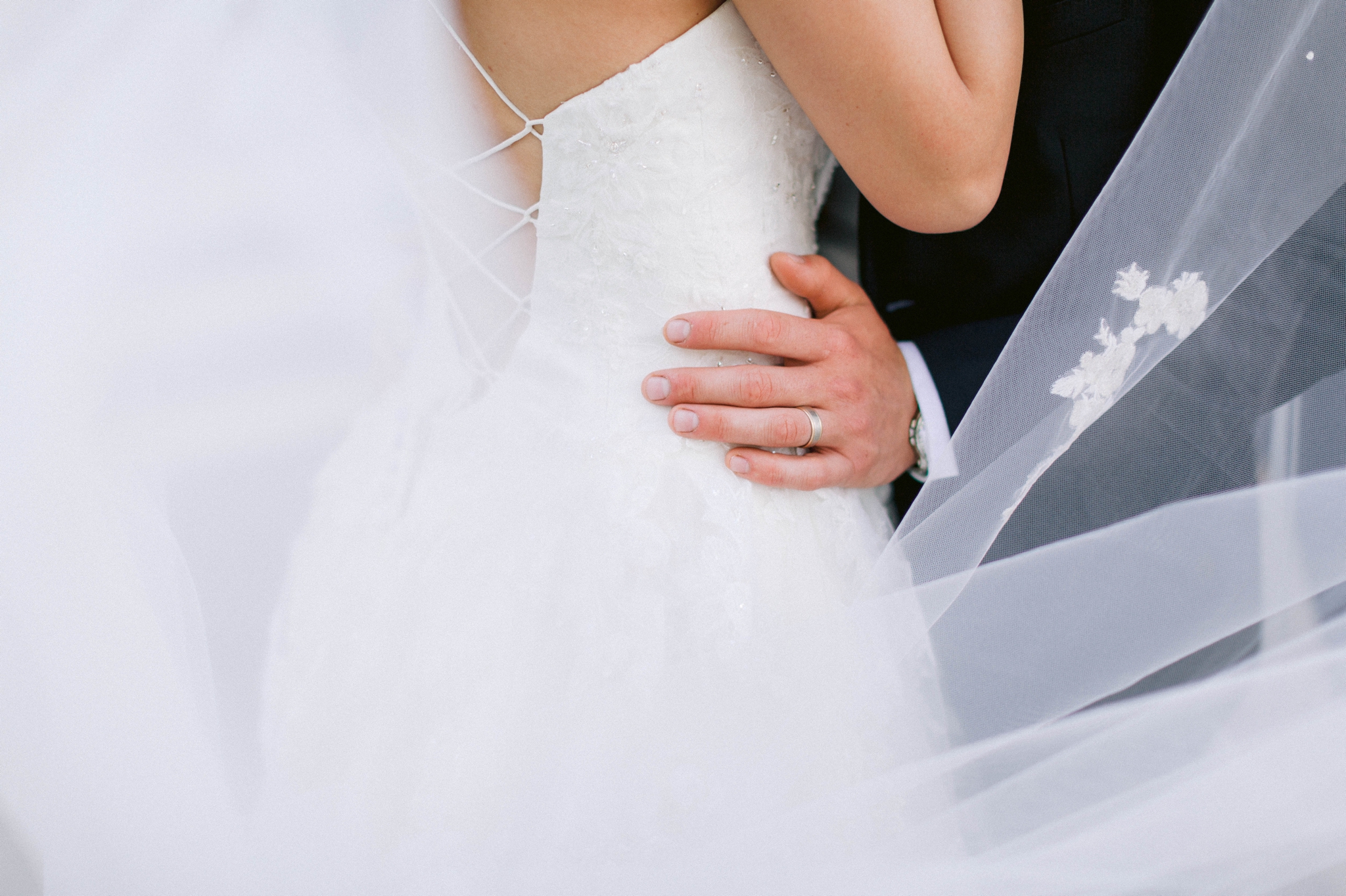  Veil shot - Wedding Portraits on the front porch of an all white luxury estate - Bride is wearing a Aline Ballgown by Cherish by Southern Bride with a long cathedral veil - Groom is wearing a black suit by Generation Tux and has a man bun - Fine Art