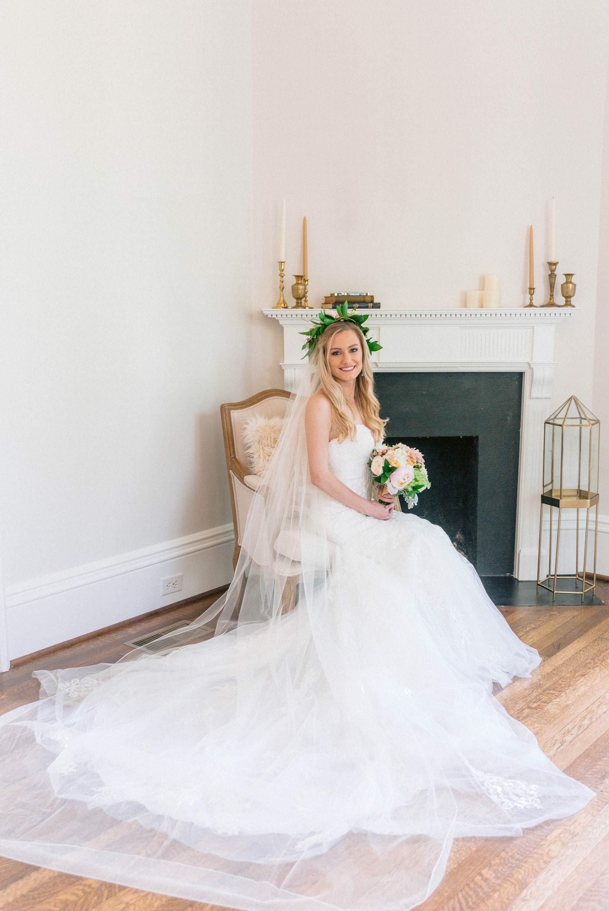  Veil shot - Indoor Bridal Portraits in an all white room at a luxury estate with natural light before the ceremony - Bride is wearing a Hawaiian Flower Crown and a cathedral veil in a Wedding Gown by Stella York sitting on an antique vintage chair i