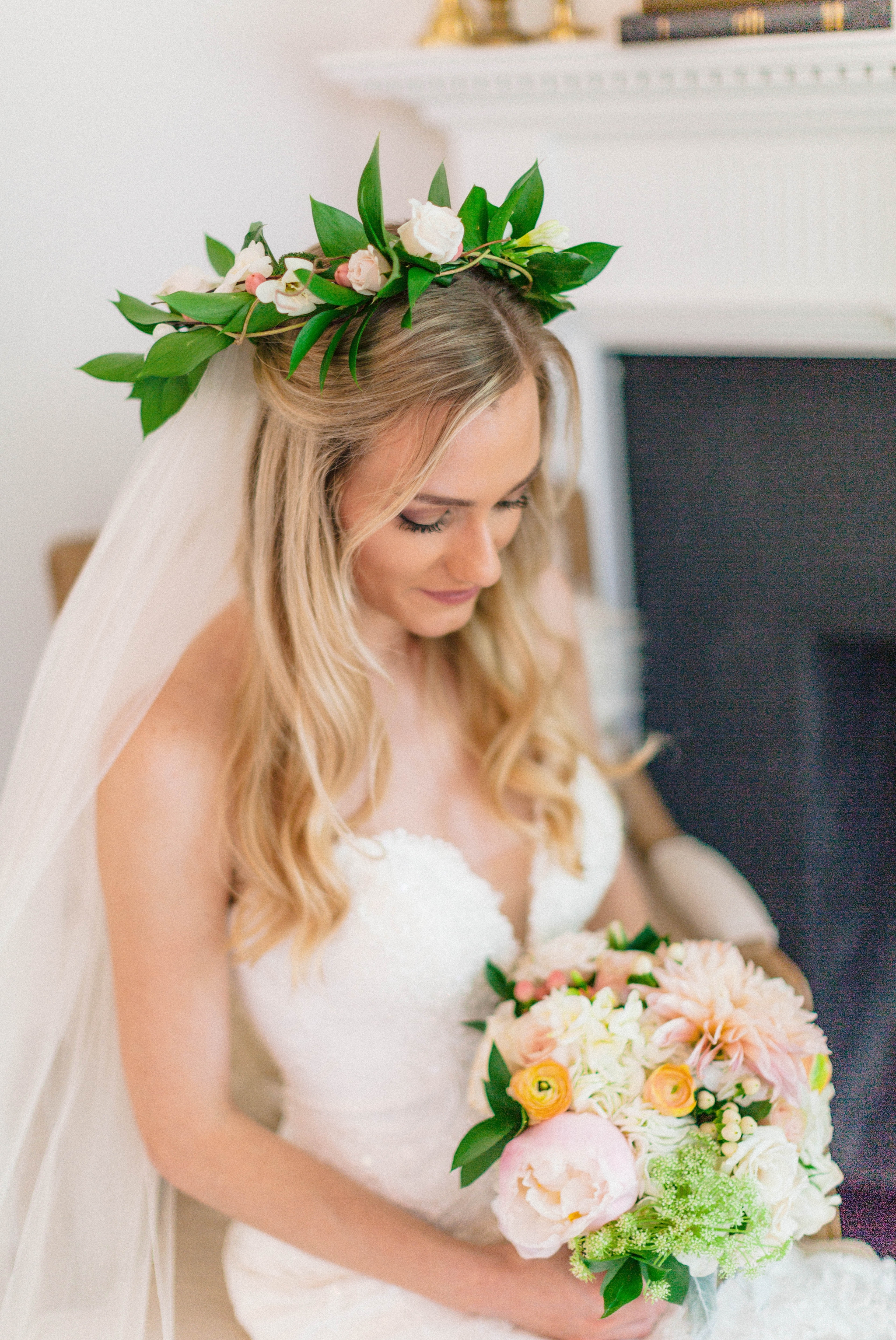   Indoor Bridal Portraits in an all white room at a luxury estate with natural light before the ceremony - Bride is wearing a Hawaiian Flower Crown and a cathedral veil in a Wedding Gown by Stella York sitting on an antique vintage chair in front of 