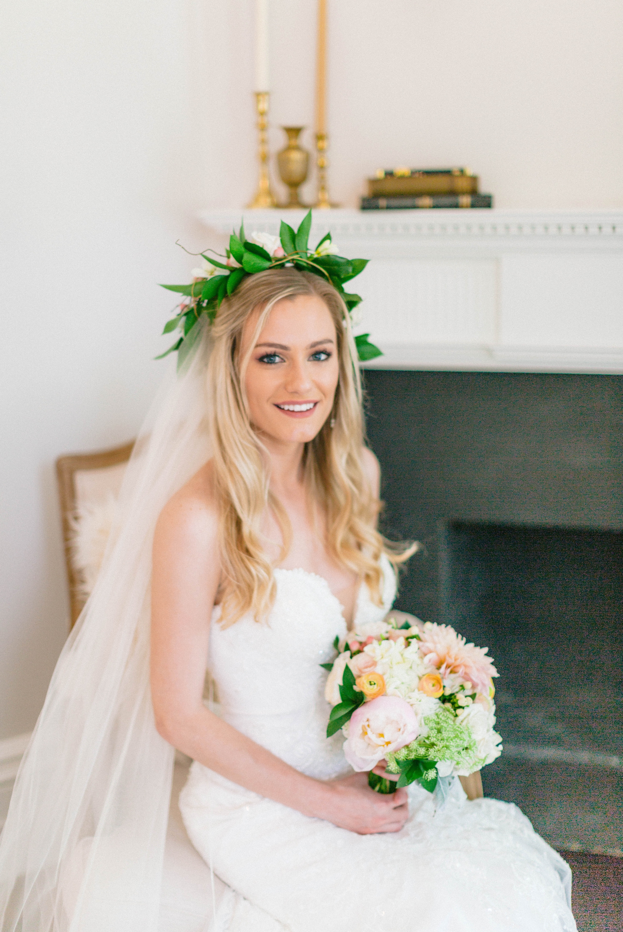  Indoor Bridal Portraits in an all white room at a luxury estate with natural light before the ceremony - Bride is wearing a Hawaiian Flower Crown and a cathedral veil in a Wedding Gown by Stella York sitting on an antique vintage chair in front of a