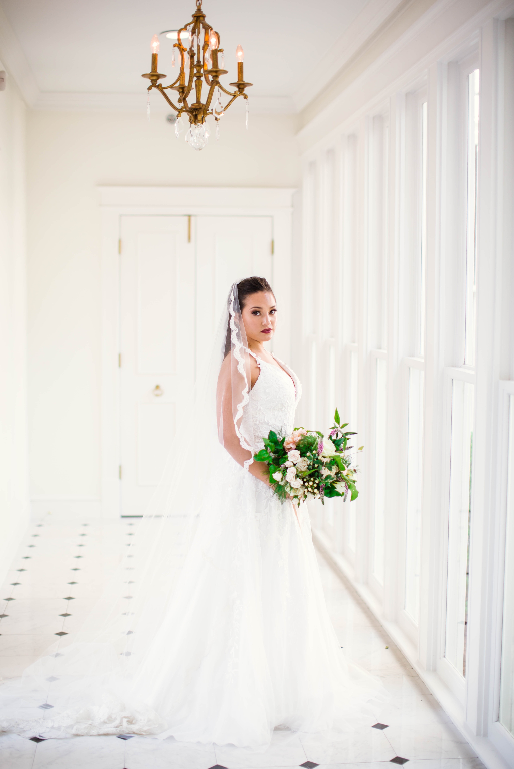  Natural light Bridal Portraits in an all white luxury estate venue with black and white floors and a golden chandelier - Bride is wearing a Wedding Dress by Sherri Hill - shot with available window light - Fine Art Wedding Photographer in Honolulu O