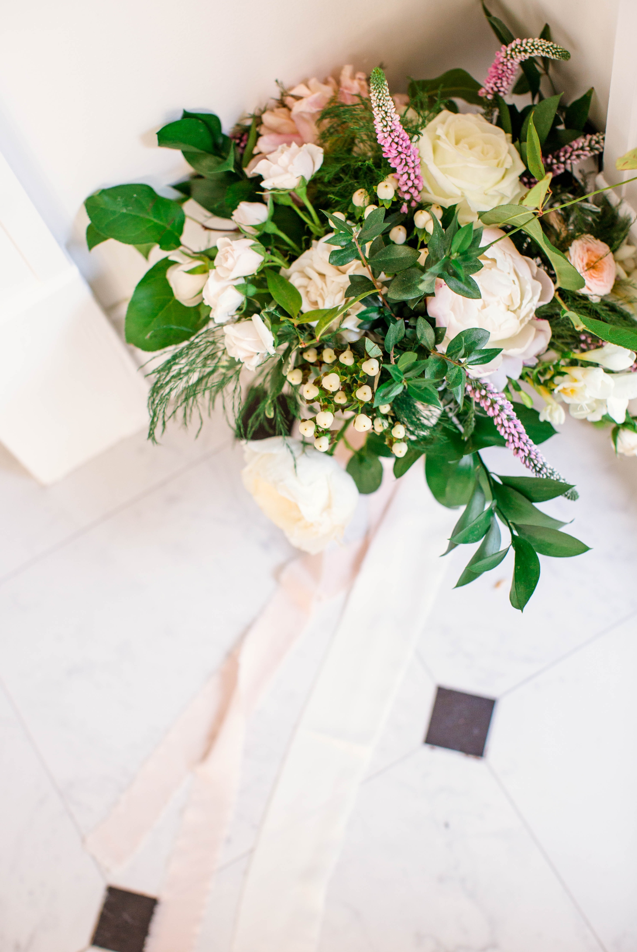  Bridal Bouquet with greenery and white flowers and paste tones on a black and white marble floor - Fine Art Wedding Photographer in Honolulu, Oahu, Hawaii - edited with the for the love of film presets by jose villa  