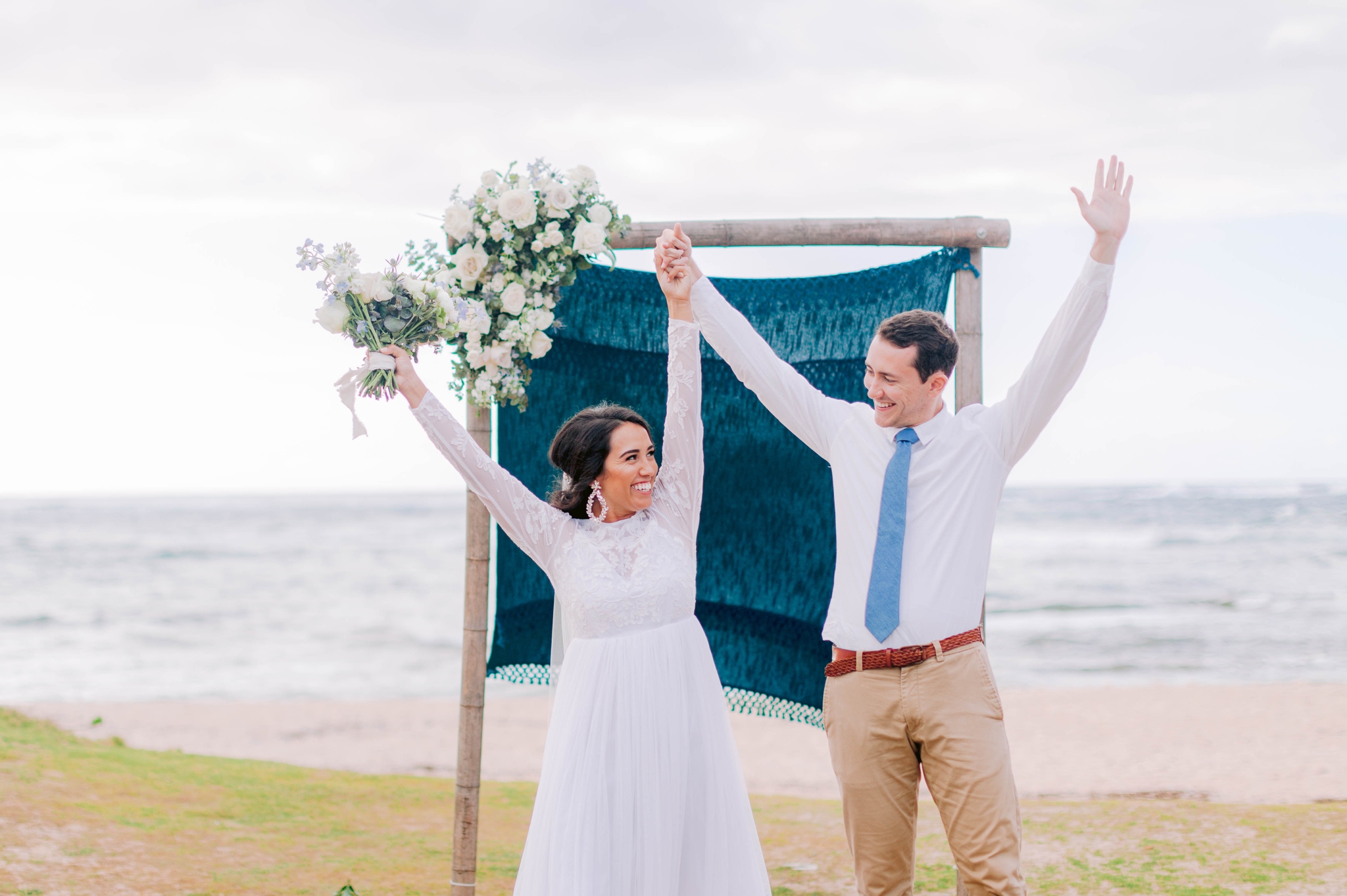 Bride and Groom cheering at the ceremony at the beach - Ana + Elijah - Wedding at Loulu Palm in Haleiwa, HI - Oahu Hawaii Wedding Photographer 