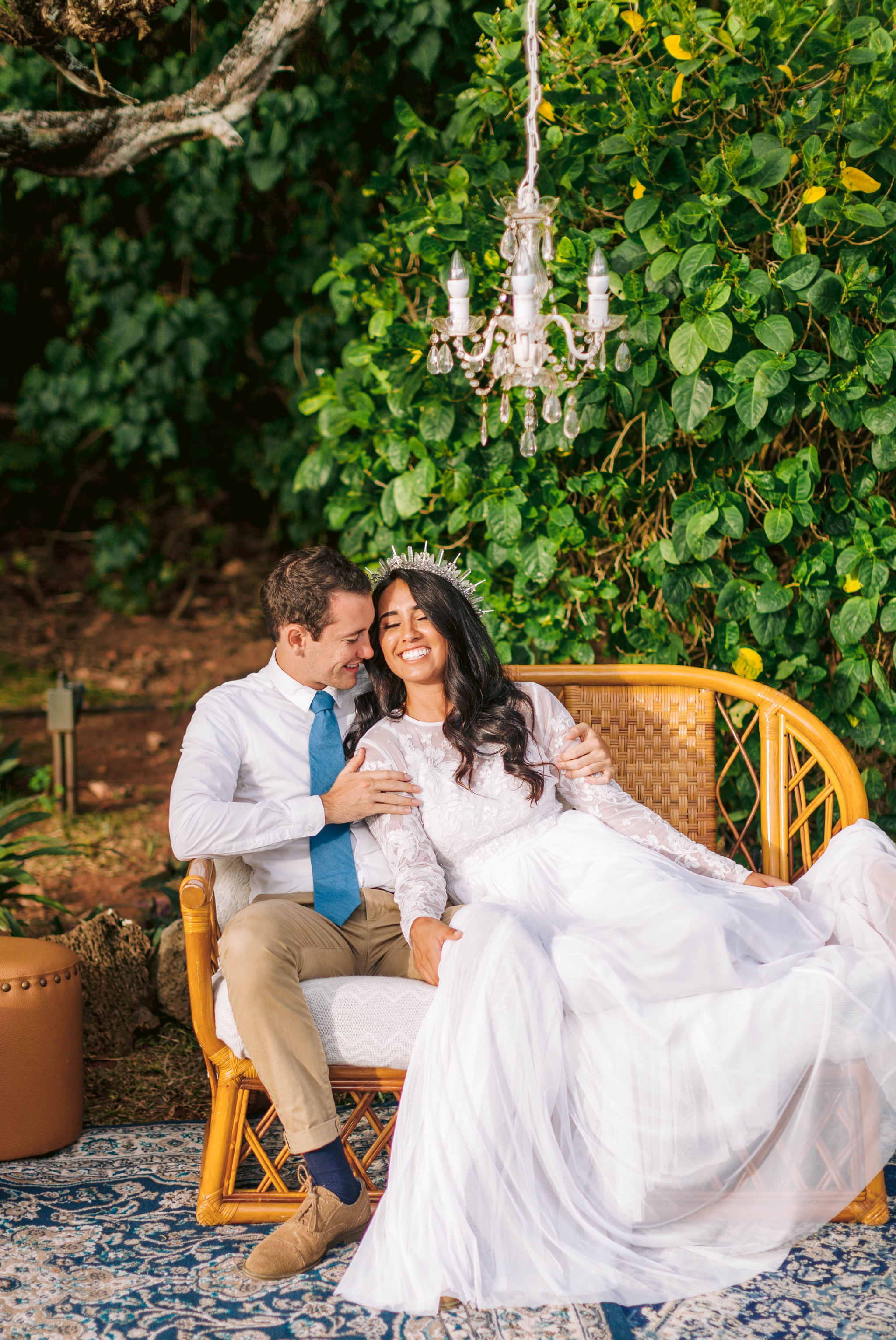  Bride and groom cuddeling an outdoor lounge - white dress by asos - unique crystal crown Ana + Elijah - Wedding at Loulu Palm in Haleiwa, HI - Oahu Hawaii Wedding Photographer - #hawaiiweddingphotographer #oahuweddings #hawaiiweddings 