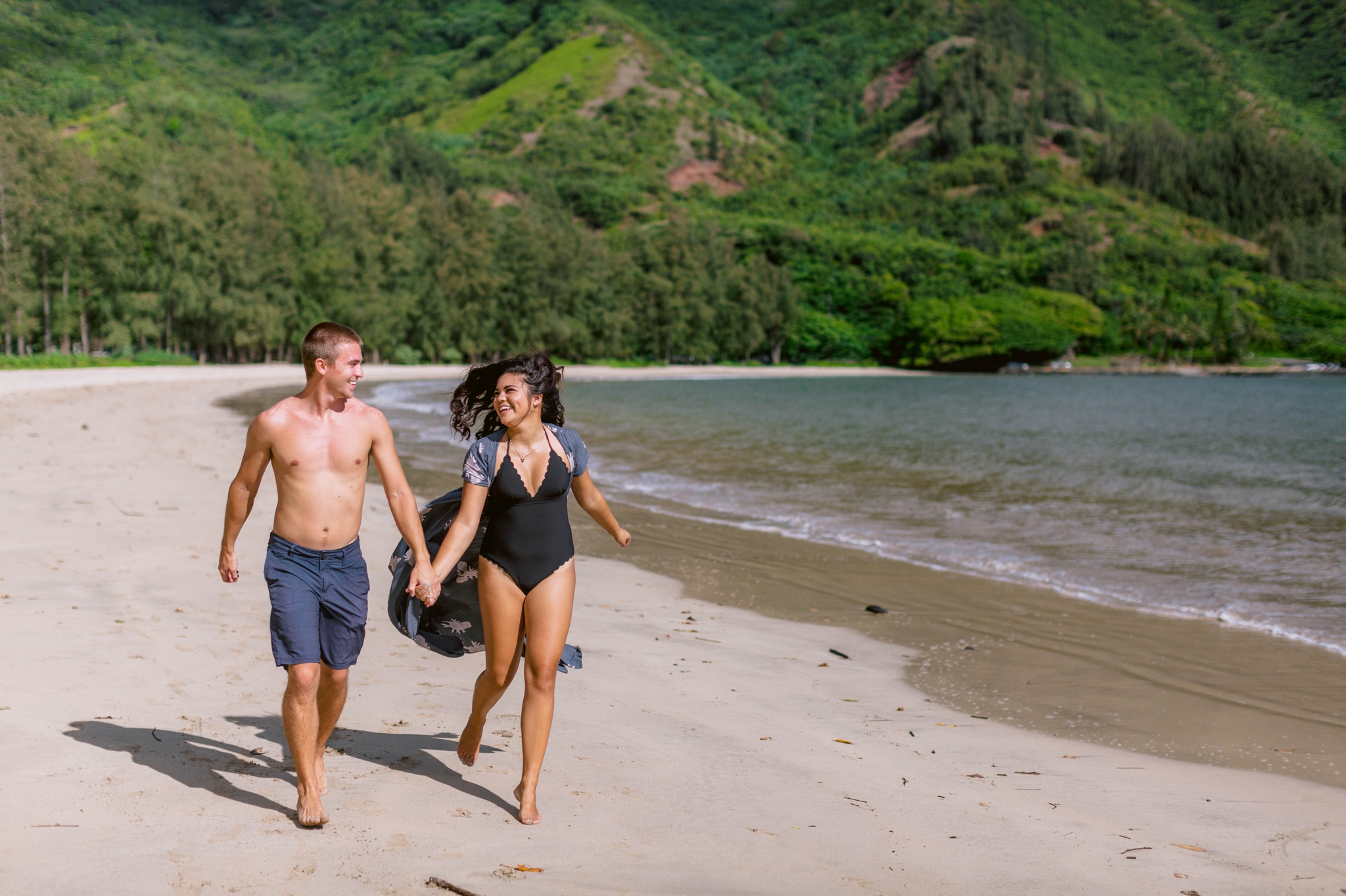  Couple running in their bathing suits - Rilee + Max - Beach Engagement Session at Kahana Bay in Kaaawa, HI - Oahu Hawaii Wedding Photographer - #hawaiiengagementphotographer #oahuengagementphotographer 