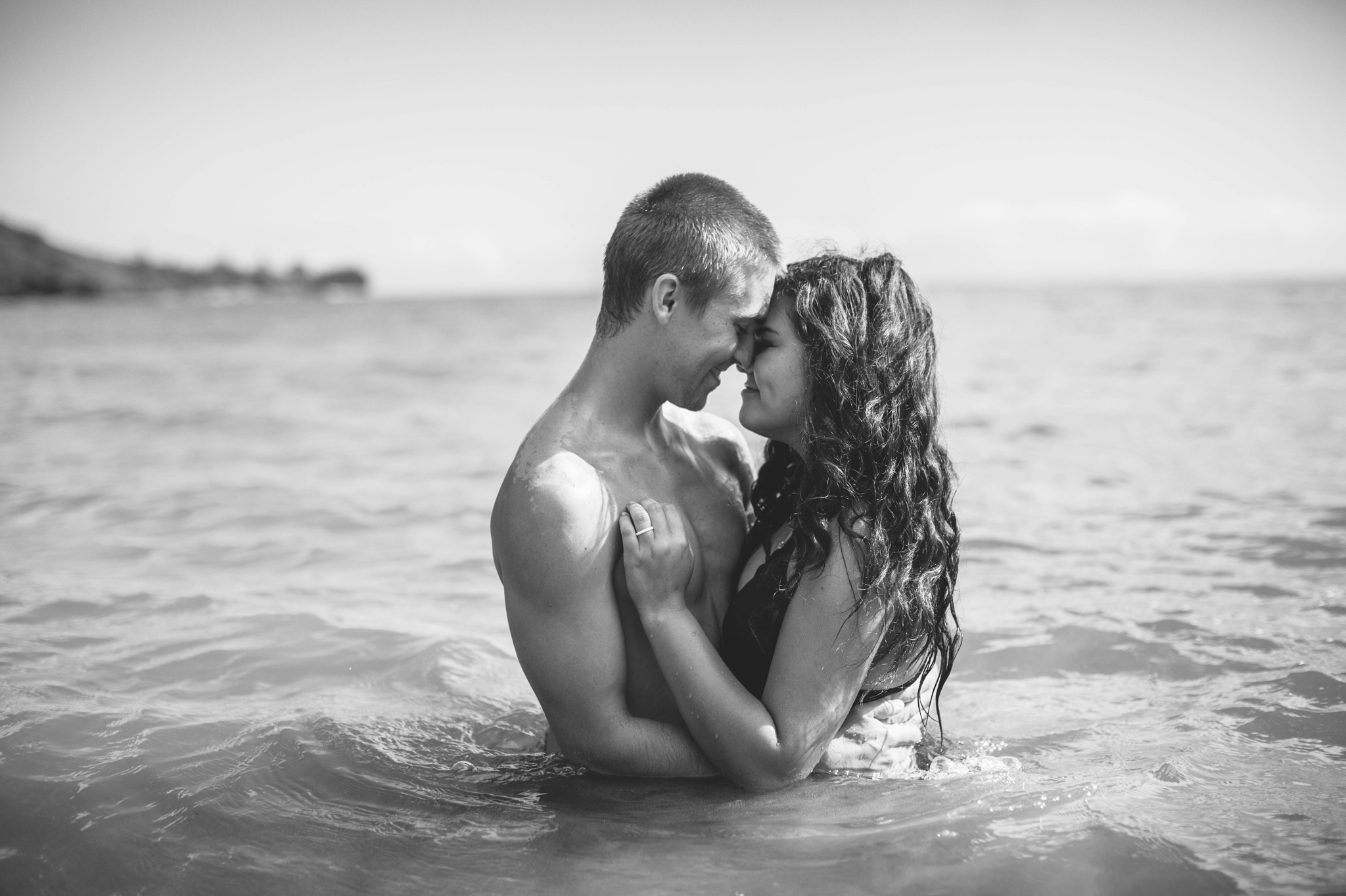  Couple kissing in the ocean in their bathing suits - Rilee + Max - Beach Engagement Session at Kahana Bay in Kaaawa, HI - Oahu Hawaii Wedding Photographer - #hawaiiengagementphotographer #oahuengagementphotographer 