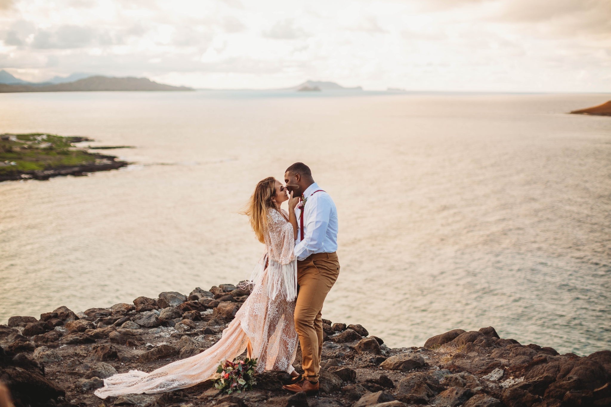  couple on the cliffs above Makapuu Beach at the Lookout, Waimanalo, HI - Oahu Hawaii Engagement Photographer - Bride in a flowy fringe boho wedding dress - lanikai lookout - deutsche hochzeits fotografin in hawaii - smal1 - dark and moody - true to 