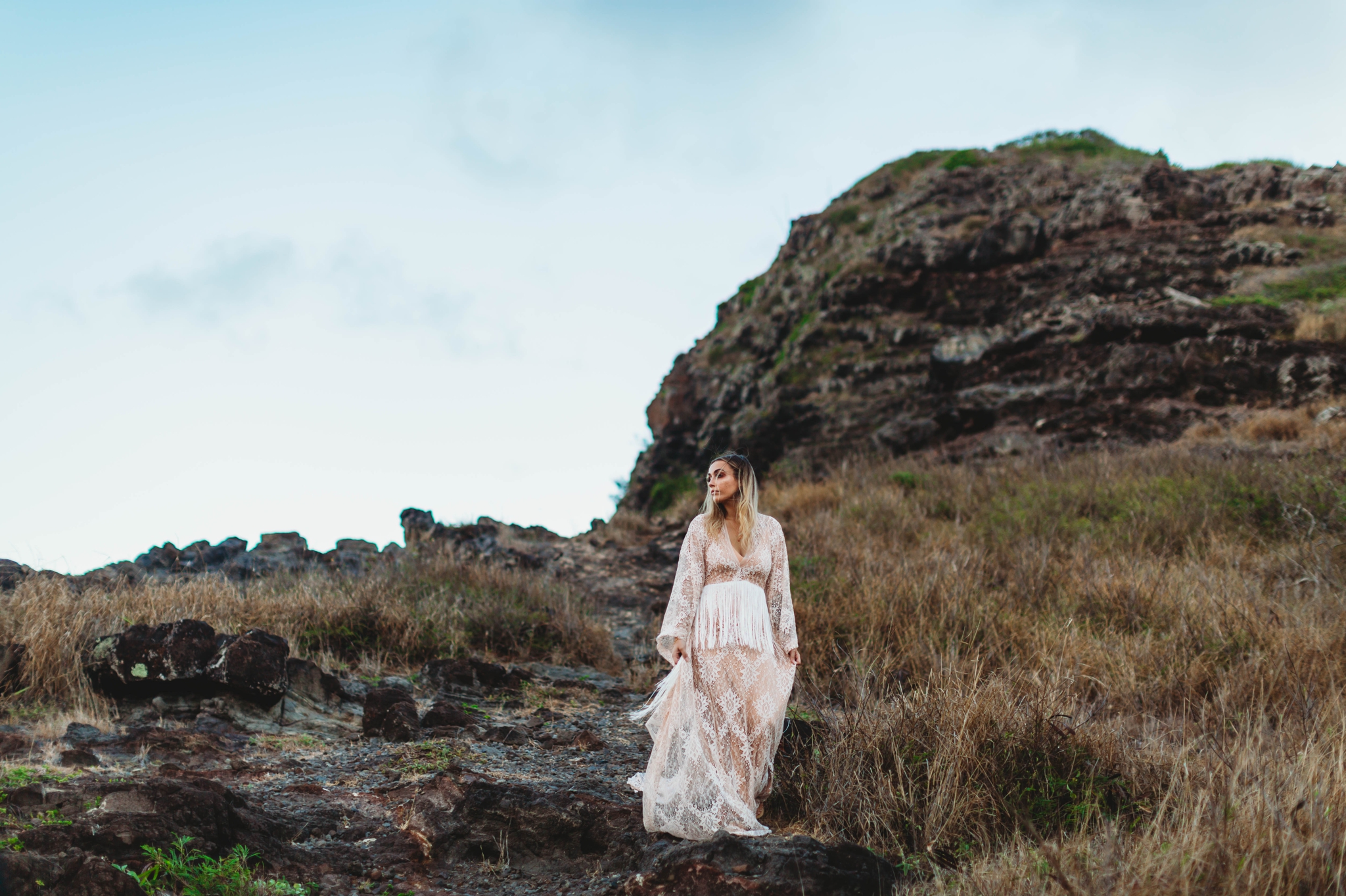  bride standing on top of a mountain - Elopement at Makapuu Lookout, Waimanalo, HI - Oahu Hawaii Engagement Photographer - Bride in a flowy fringe boho wedding dress - lanikai lookout - deutsche hochzeits fotografin in hawaii - smal1 - dark and moody