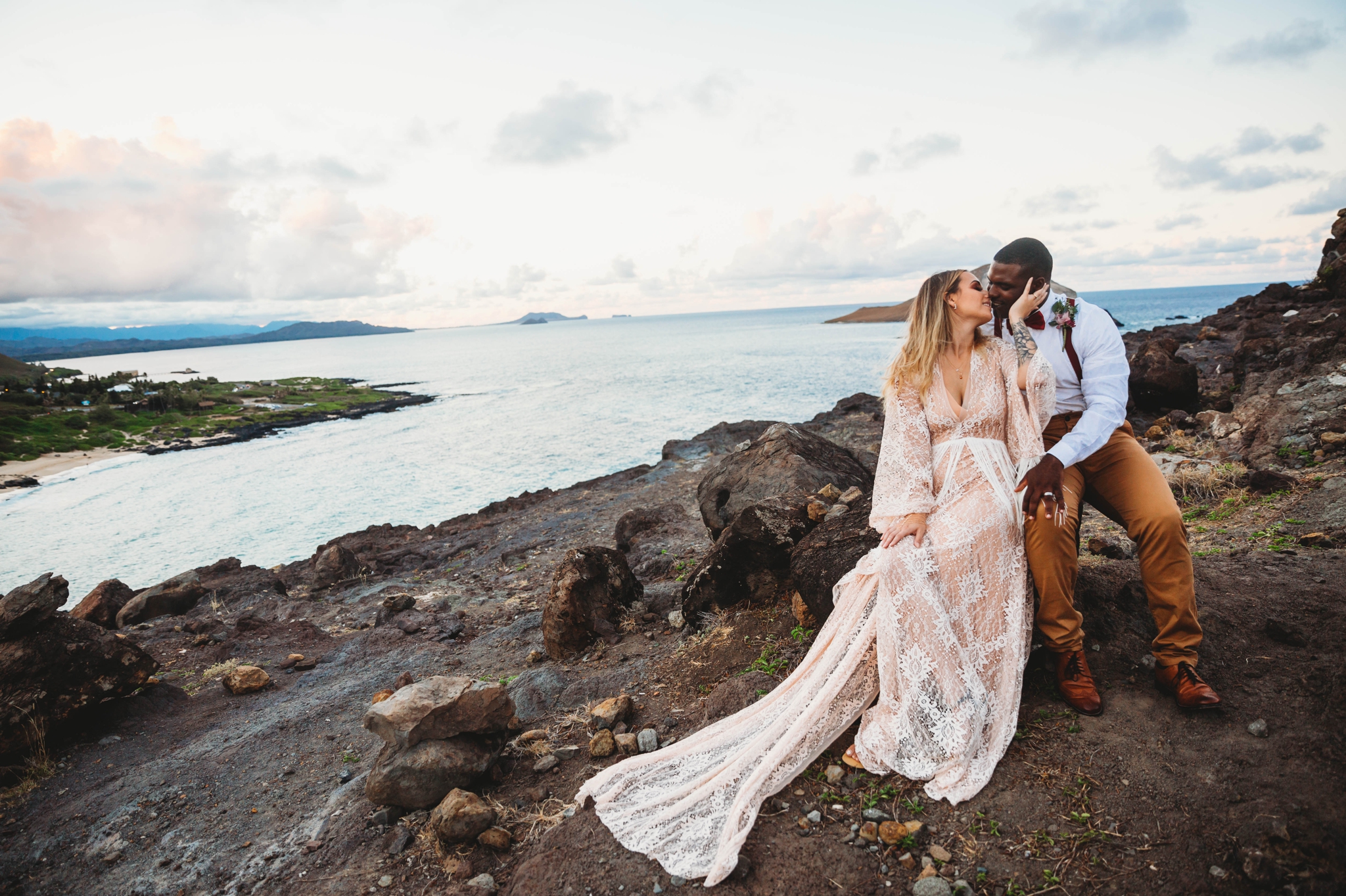 couple kissing on the cliffs above Makapuu Beach at the Lookout, Waimanalo, HI - Oahu Hawaii Engagement Photographer - Bride in a flowy fringe boho wedding dress - lanikai lookout - deutsche hochzeits fotografin in hawaii - smal1 - dark and moody - true to live