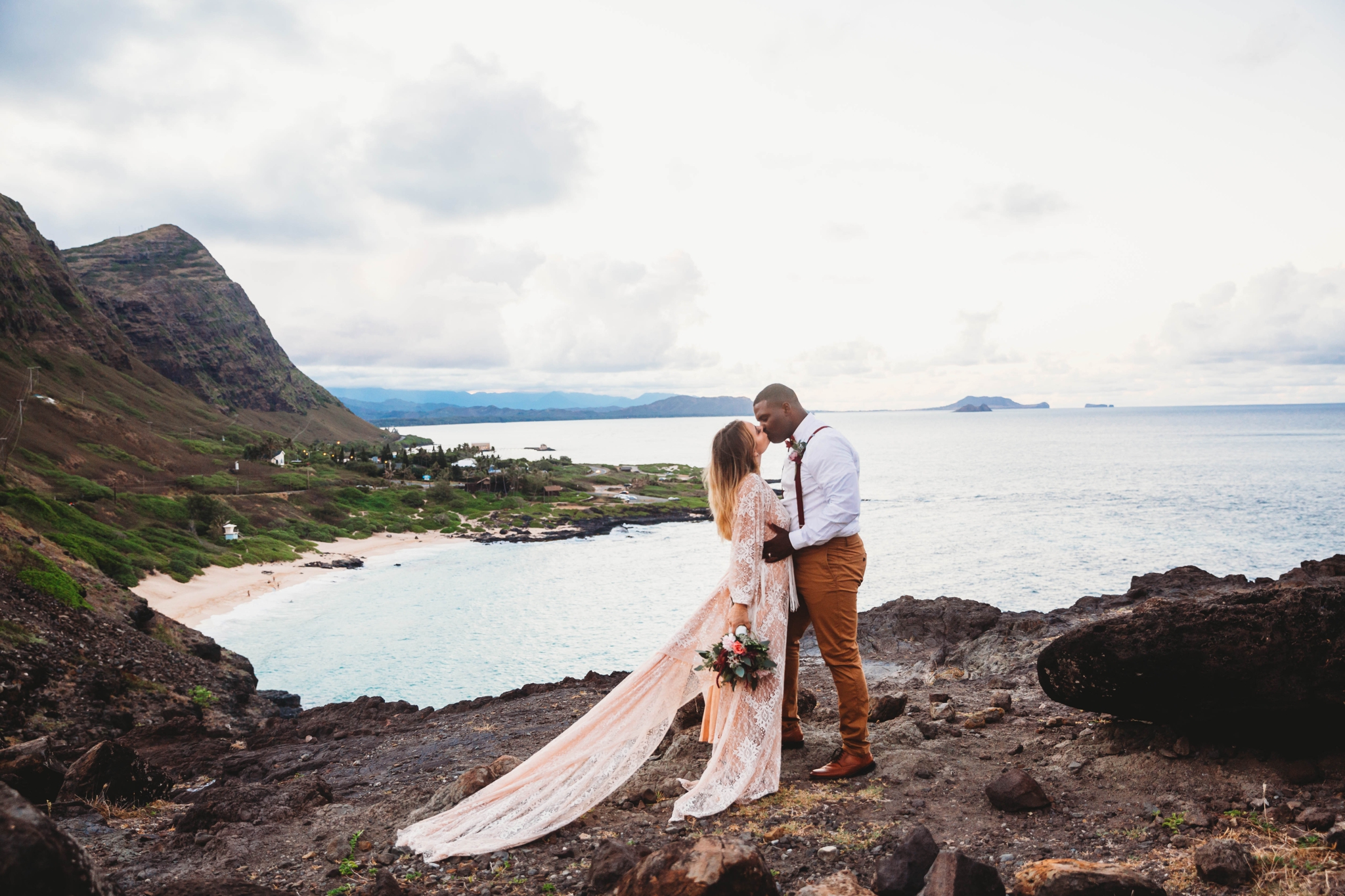 first kiss between bride and groom - wedding ceremony at Makapuu Lookout overlooking the ocean and beach, Waimanalo, HI - Oahu Hawaii Engagement Photographer - Bride in a flowy fringe boho wedding dress - lanikai lookout - deutsche hochzeits fotografin in hawaii - smal1 - dark and moody - true to live