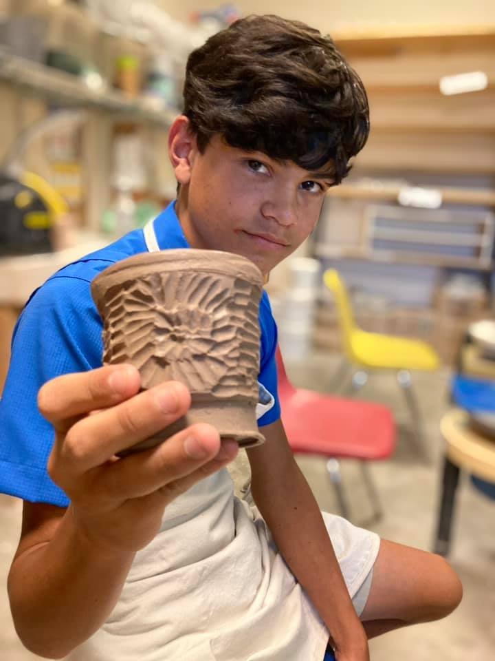 Kid with carved mug he made.jpg
