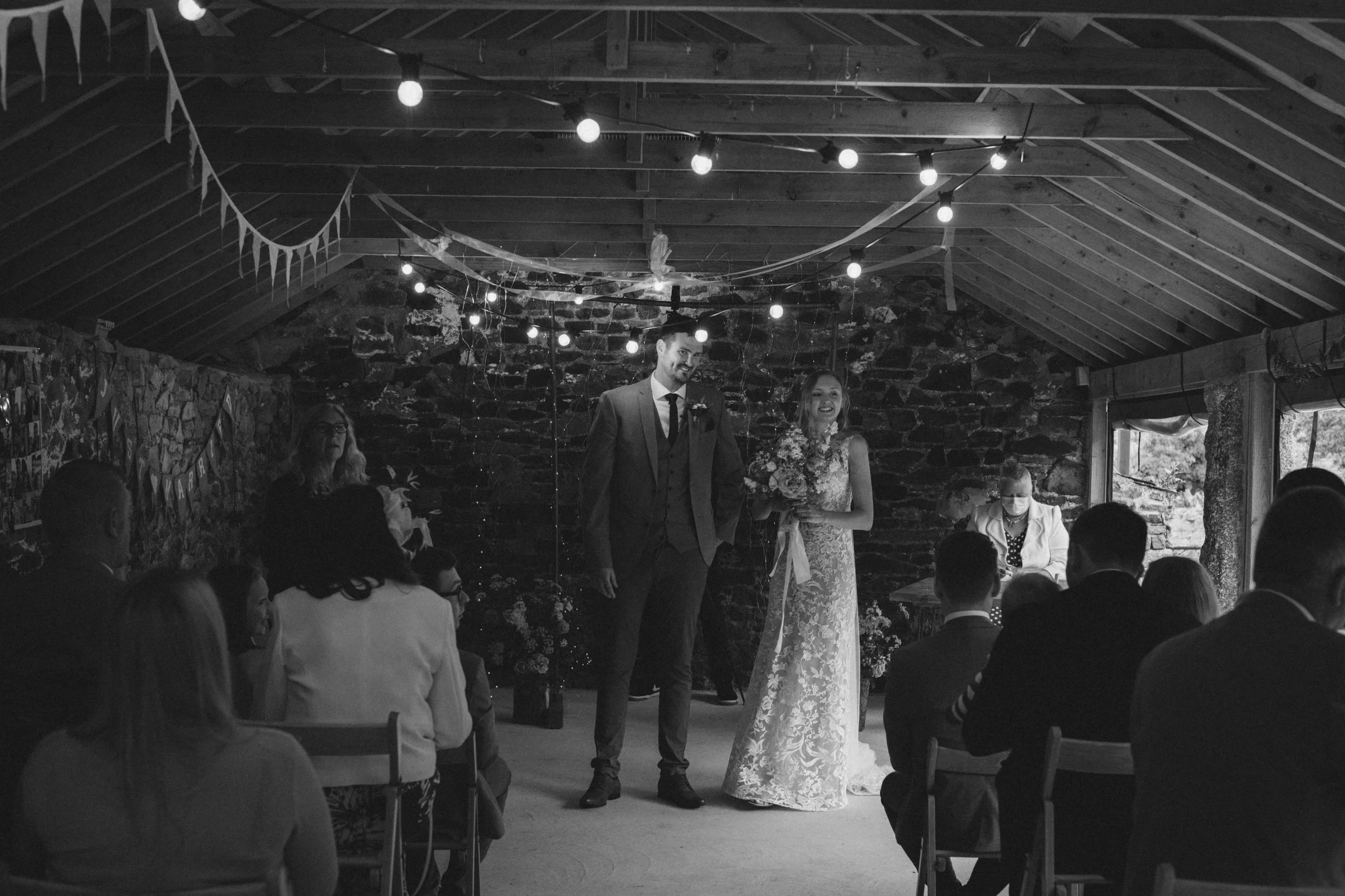 spring wedding ceremony inside the stone barn at pengenna manor