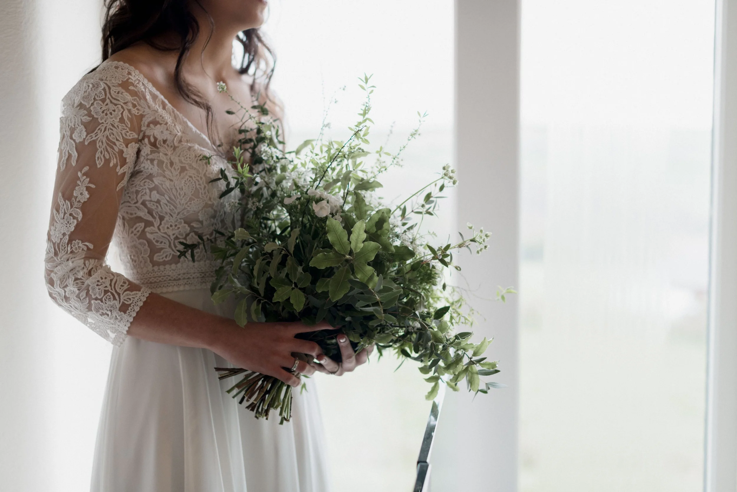 boho fairytale bride holding greenery spring wedding bouquet by Lafonia flower company in Cornwall