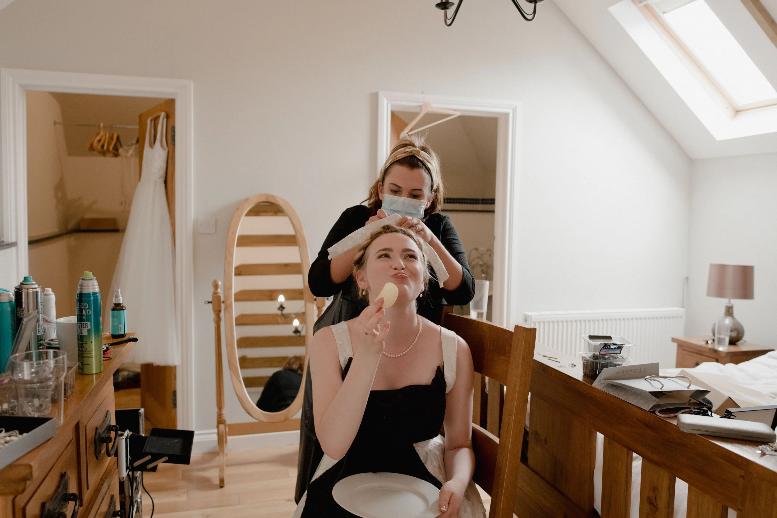 candid moments of bride eating Pringles whilst having her wedding hair and makeup done