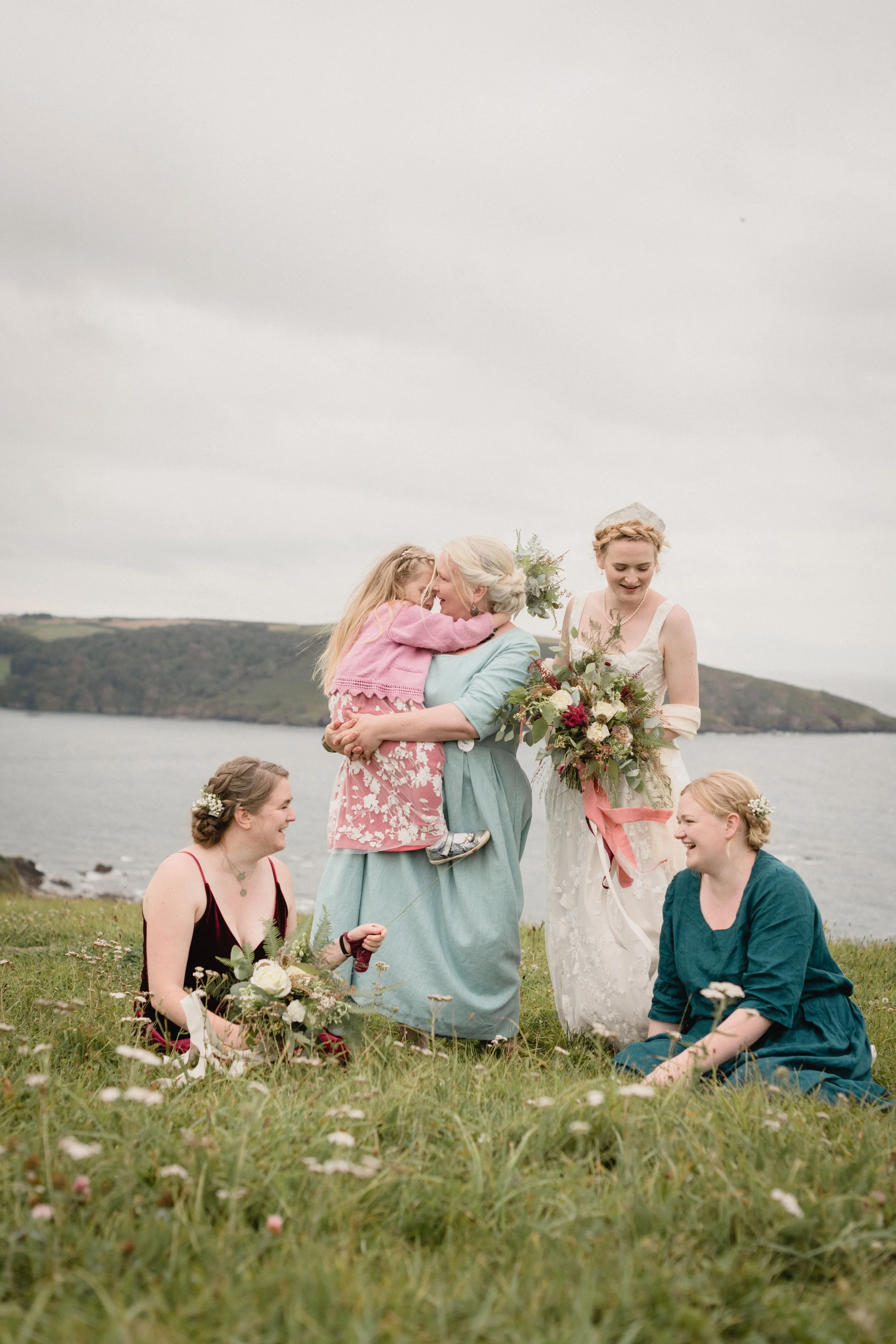 artful and poetic non traditional group photo of bridesmaids in the meadow