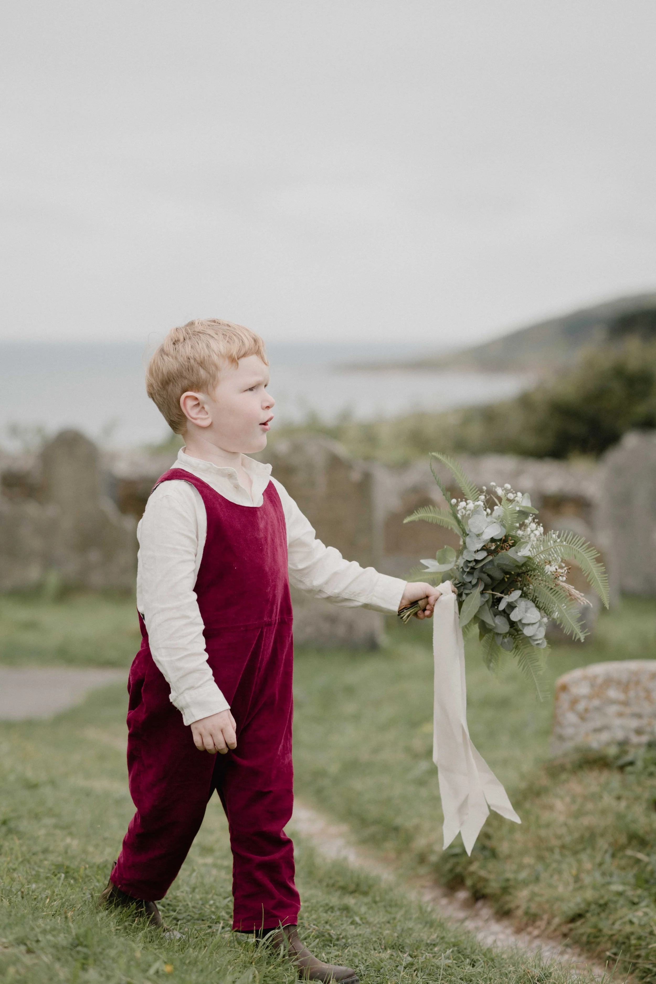 alternative page boy style in handmade red dungarees and linen for autumnal style