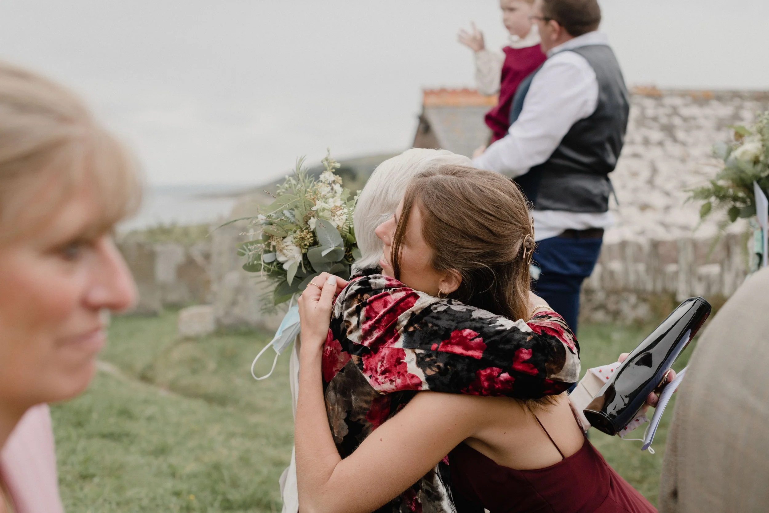 reportage moments of bridesmaid hugging her gran at outdoor alternative fairytale wedding in devon