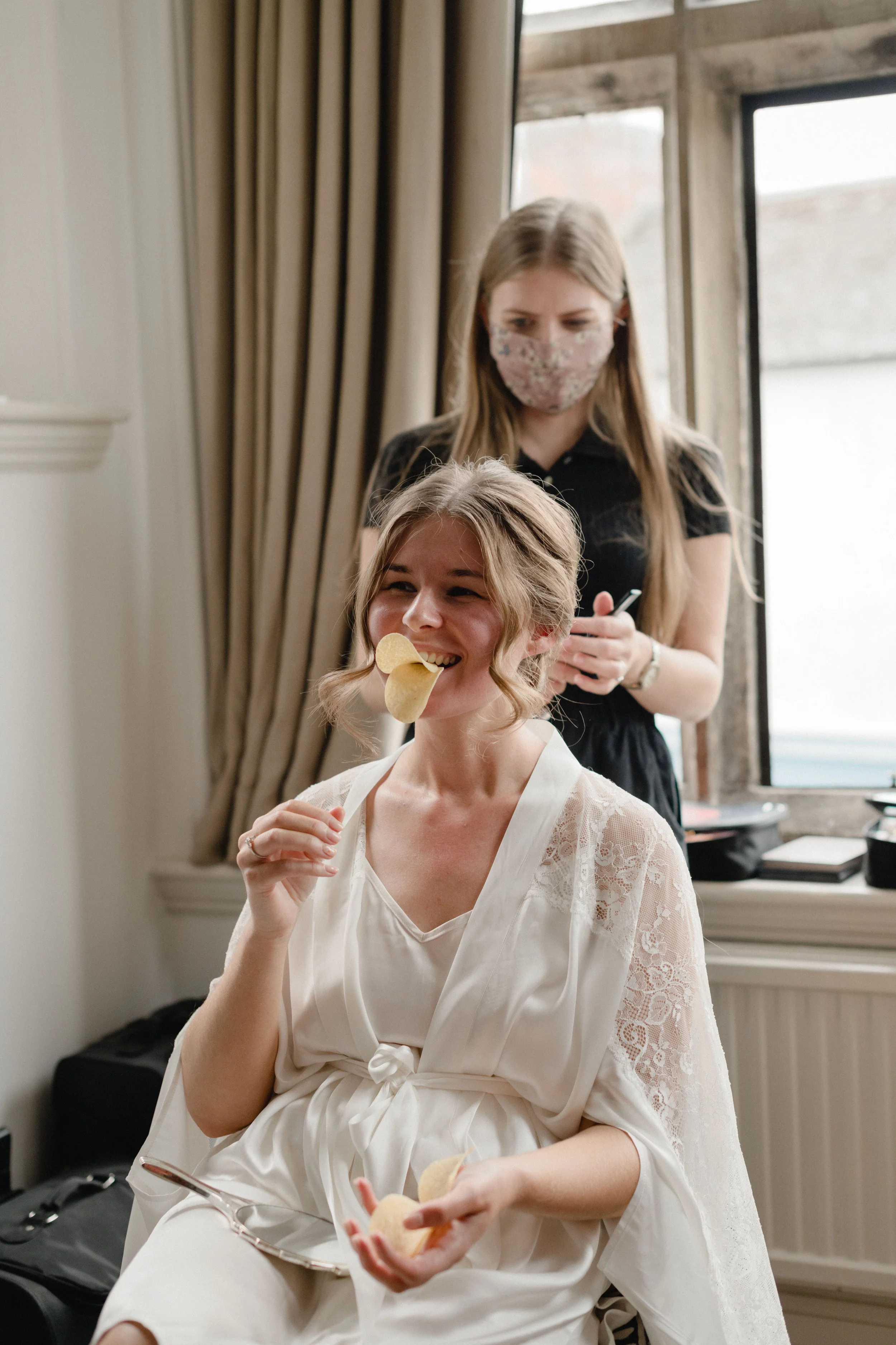 candid documentary photography of bridal preparations the morning of the wedding at the Old Bell in Malmesbury with the bride eating pringles like a duck
