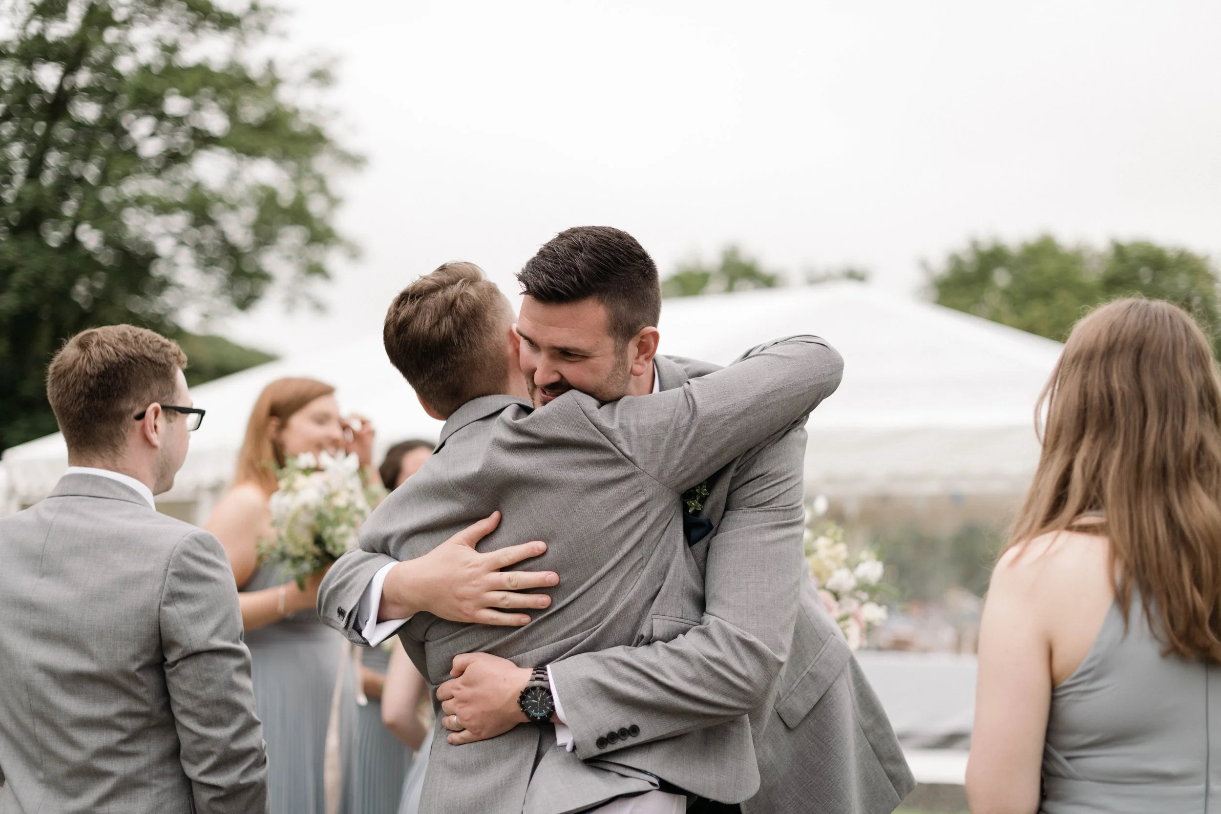 groom and groomsman share a hug at intimate spring post lockdown wedding