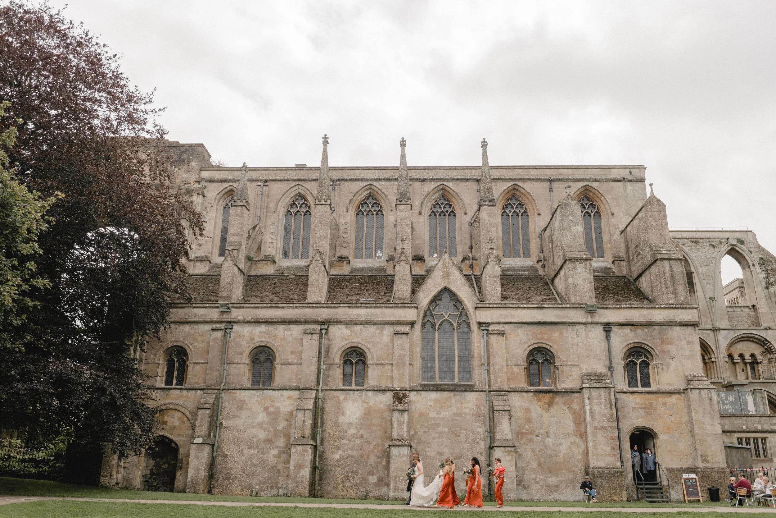 Malmesbury Abbey walking to the gardens with the bride and bridesmaids on their way to a wedding