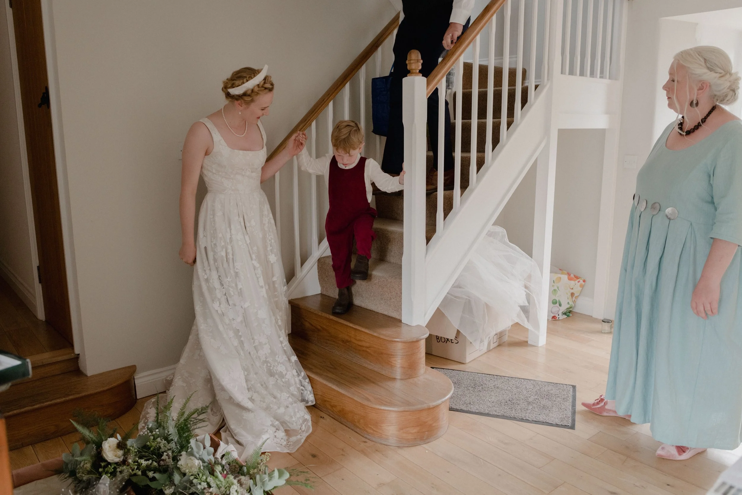 little page boy coming down the stairs in homemade red dungarees for alternative page boy style