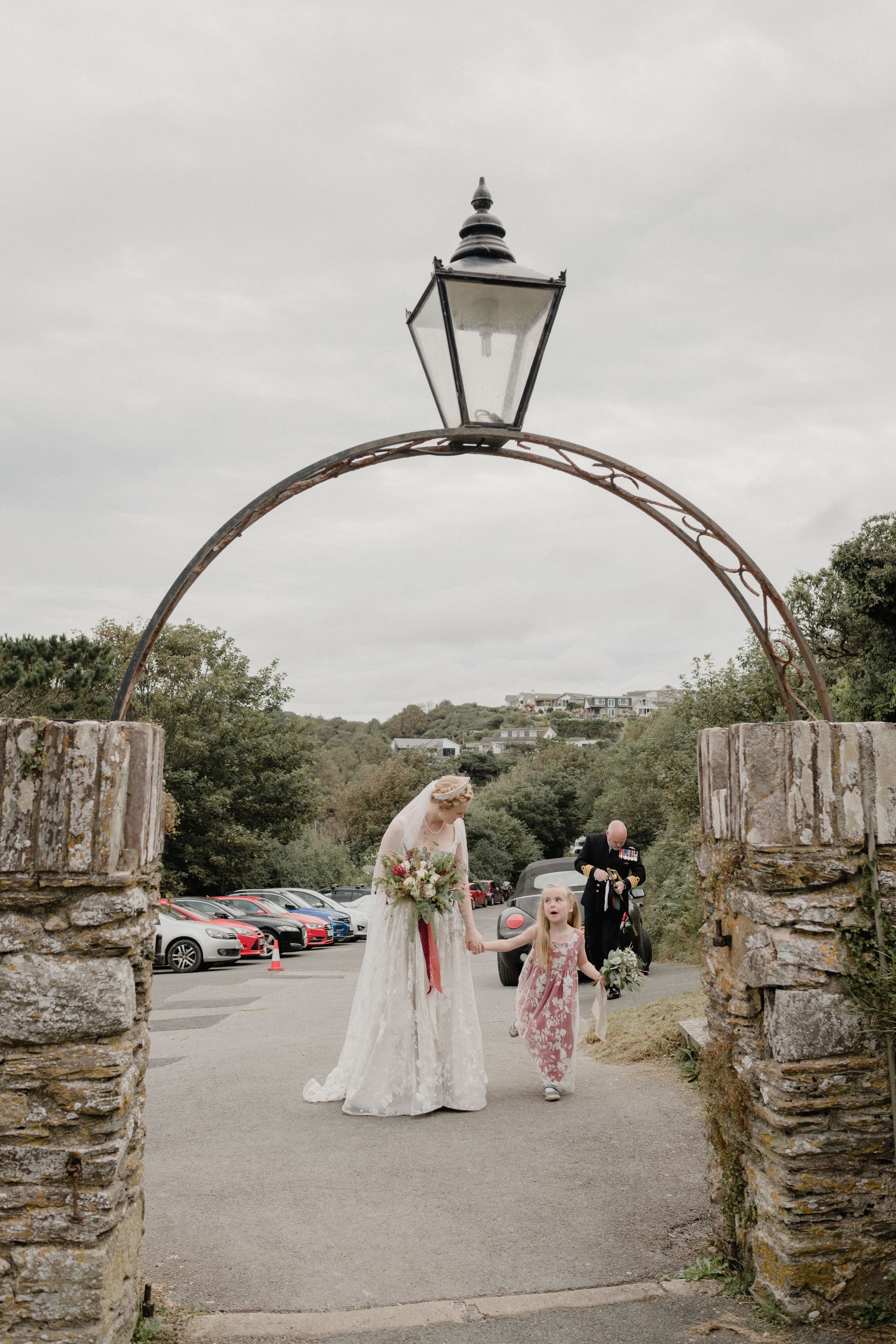 bride arriving at the church with flowergirl in pink lace