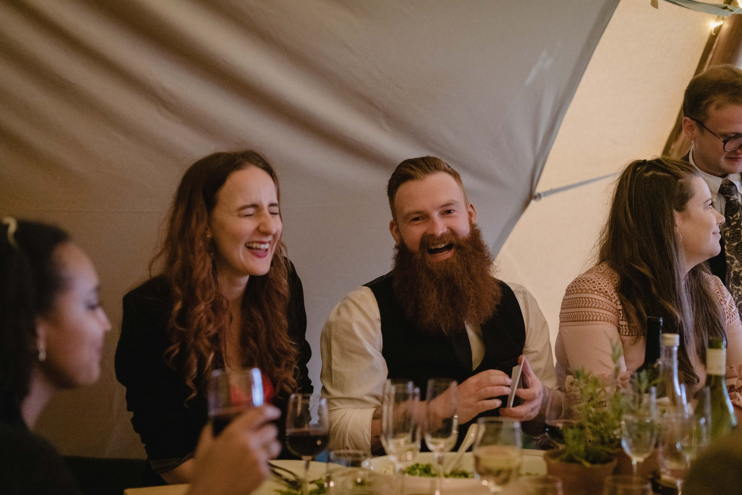 candid natural documentary moments of guests laughing inside boho tipi