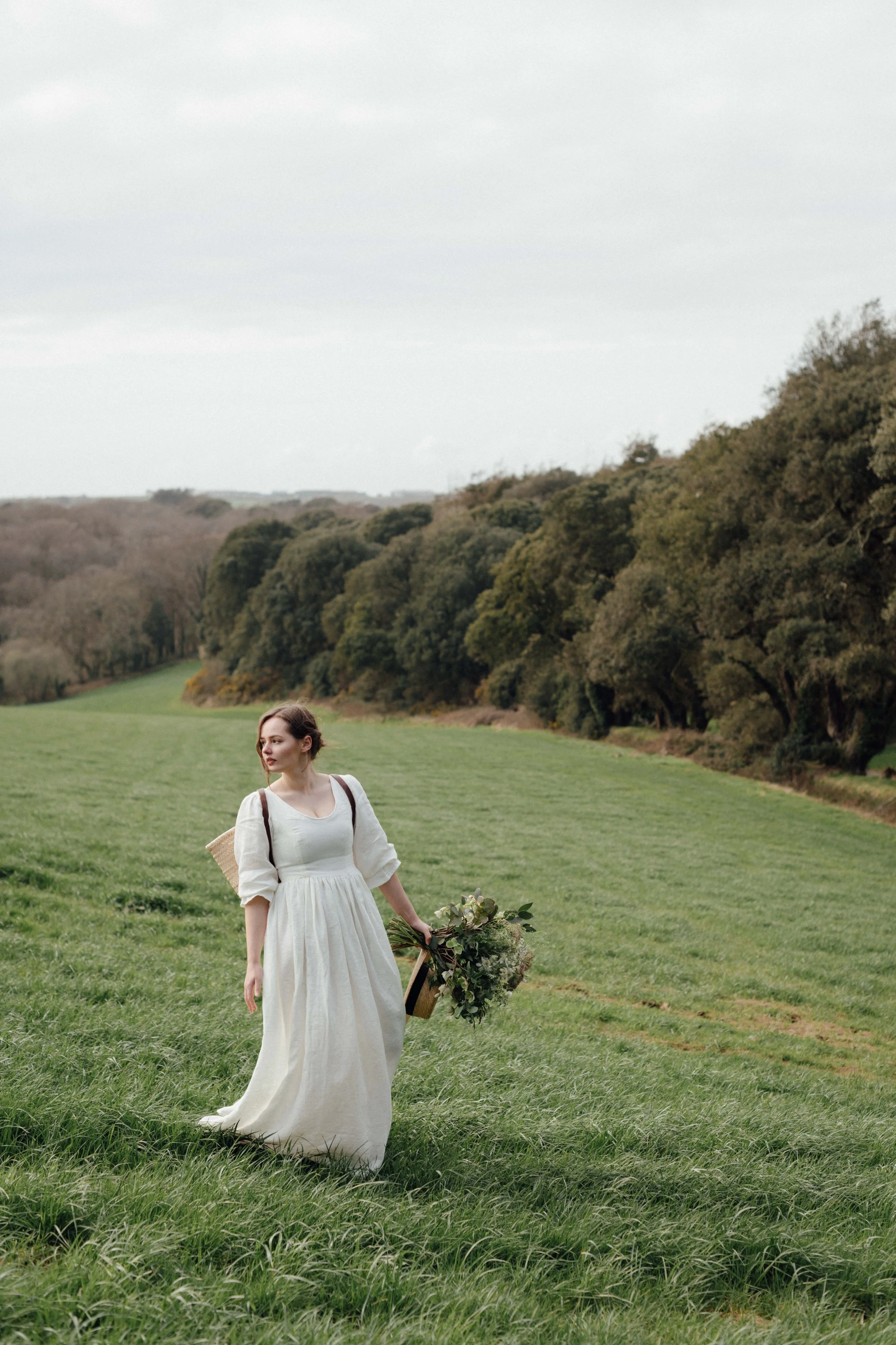 a cottagecore bride in a linen gown in a renaissance style rolling countryside setting