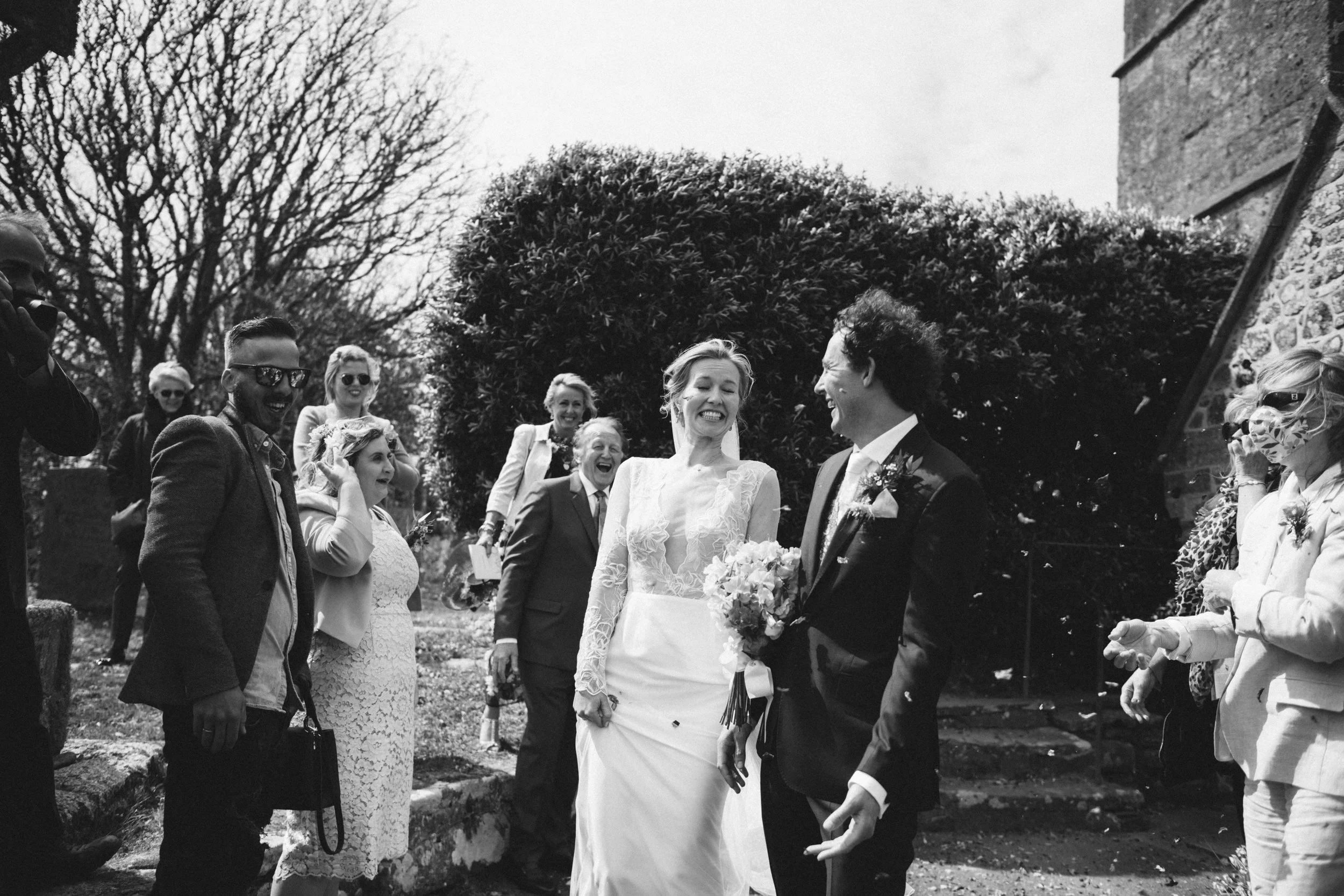 candid photography of confetti outside the church in black and white