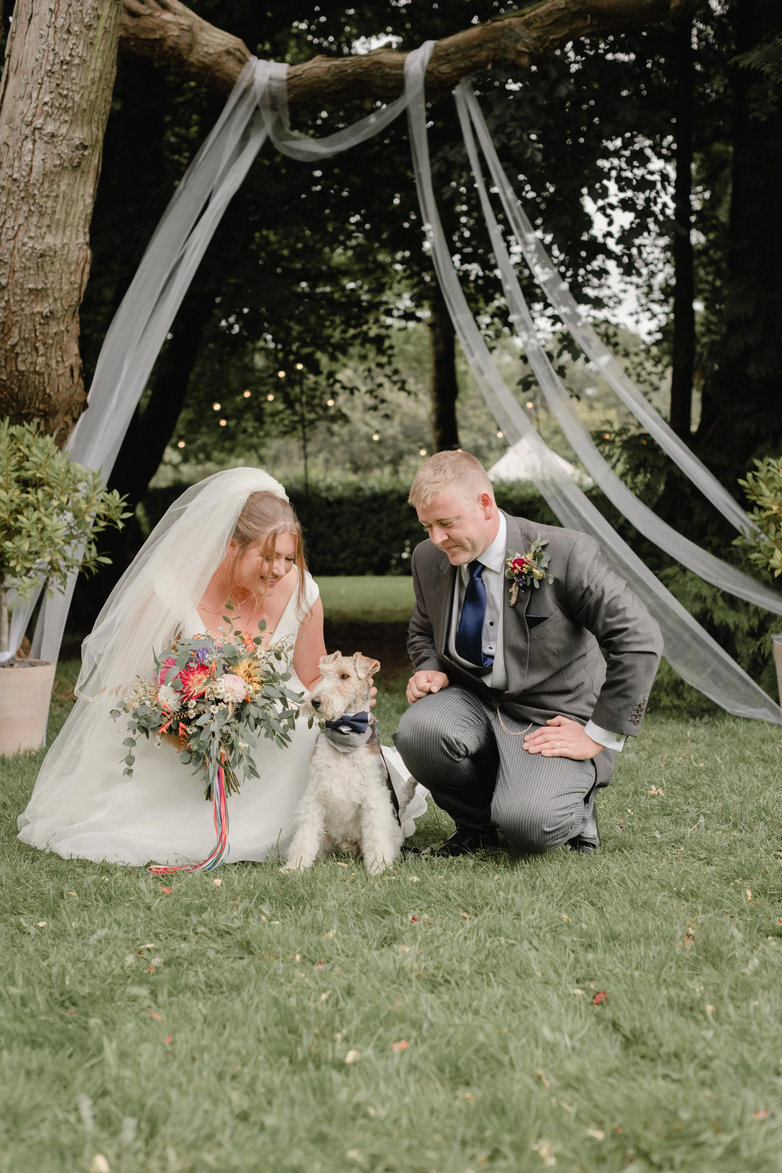 bride and groom with their dog at their outdoor wedding in cornwall