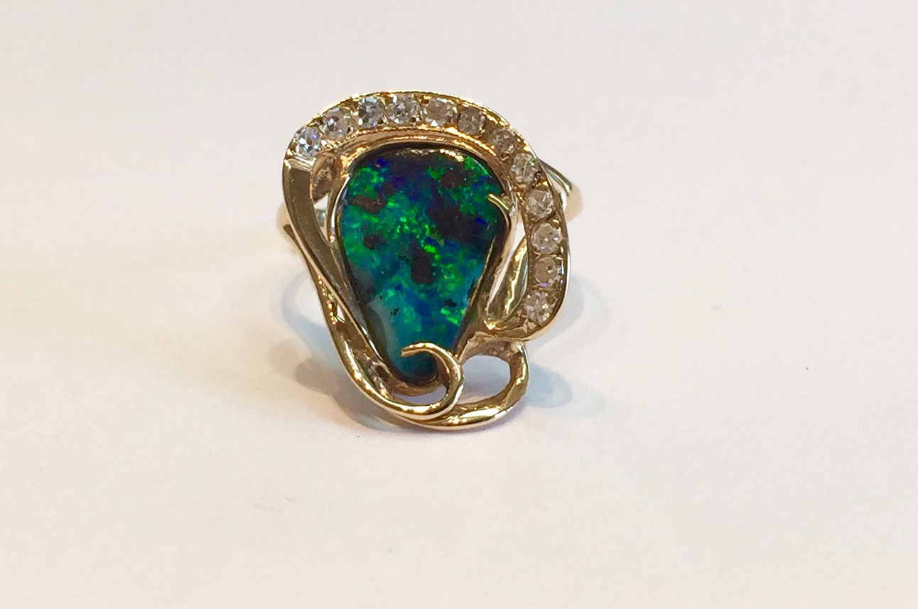 Item No A225 USD645 14K Yellow Gold, Black Opal and Diamond ring One off custom made ring. Lots of fire in the approximately 1.5 carat Australian black opal which is highlighted by an artisan's touch using gold and quality diamonds. Truly an artistic and original ring. 