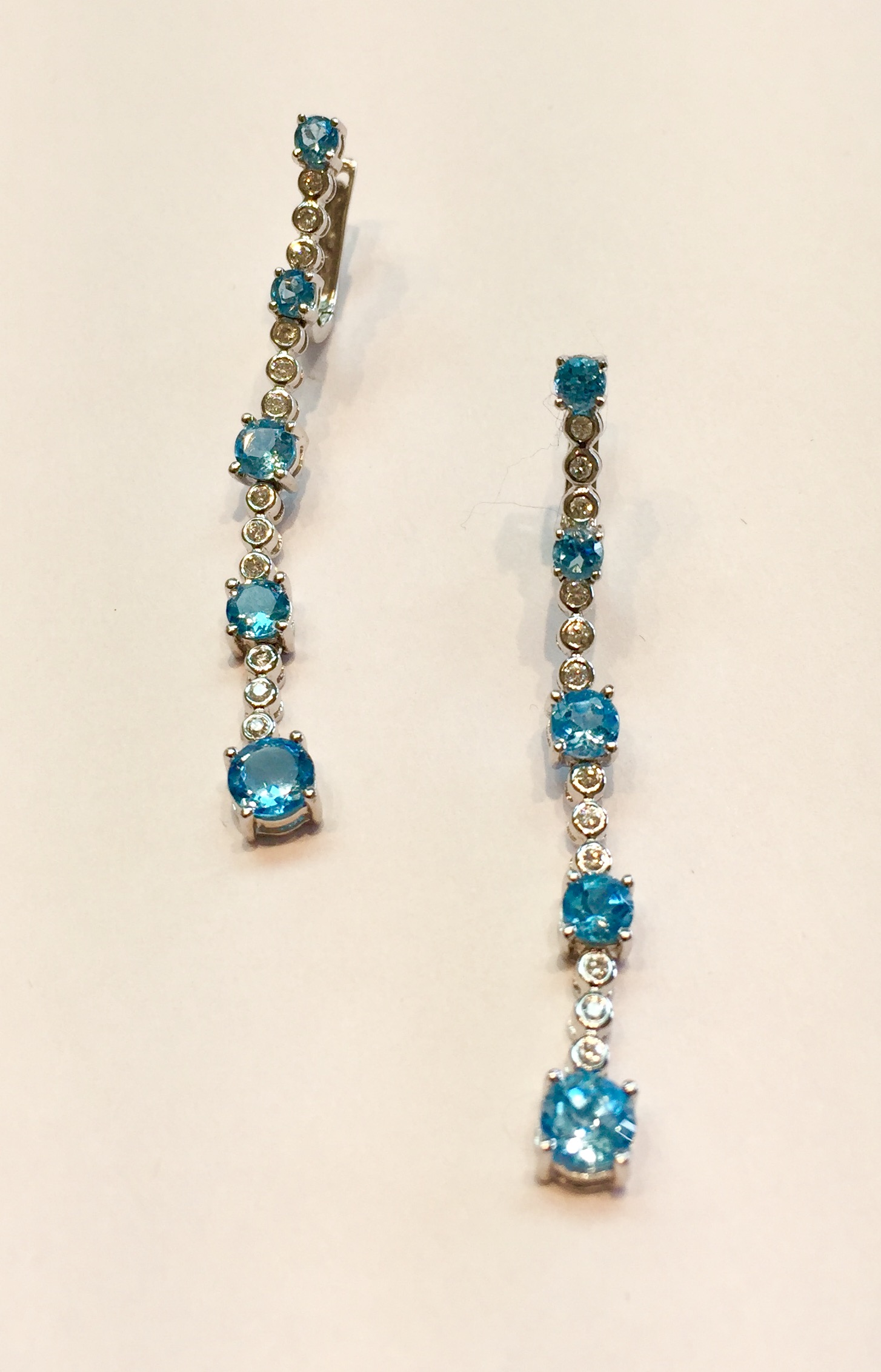 Item No AB17 USD745 14K White Gold Diamond and Topaz Earrings In each earring there are .36 diamonds and 1.38 carat of sparkling blue topaz. The dangle earrings are just short of 5 inches (47.5mm) long. Very cheerful earrings, they make me smile. 