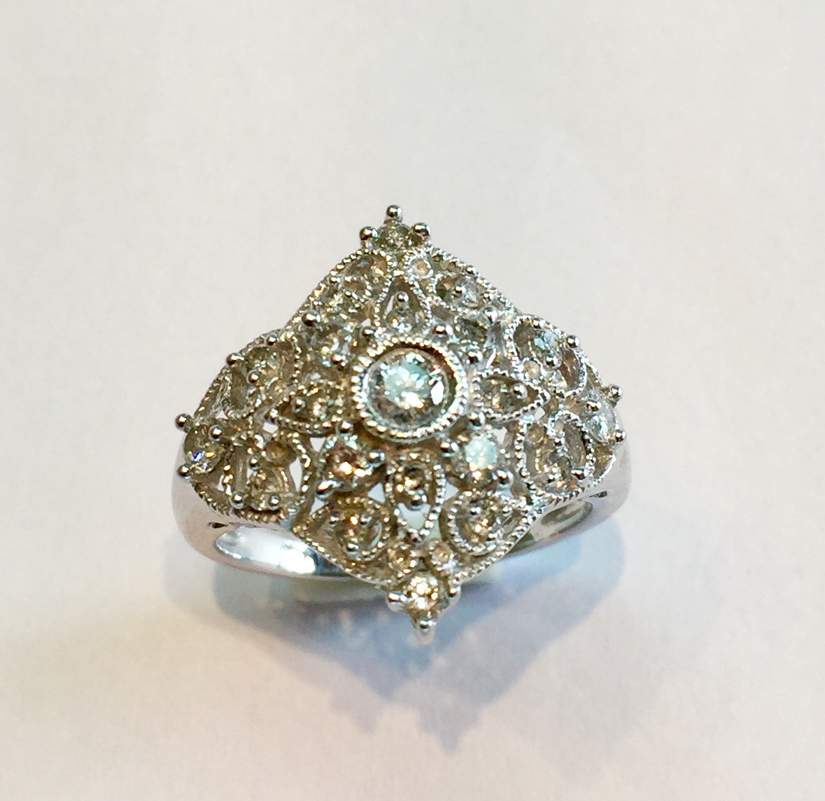 Item No AB60 USD 575 14k White Gold Diamond Ring Charming vintage look to this sparkling diamond ring. Very intricate filagree work over all the top on the ring and the centre diamond is approximately .17 of carat. 