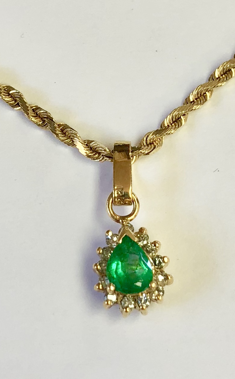 Item No. 334 USD595 Stamped 18k White Gold Emerald Diamond Pendant with 18k Chain. Lovely quality emerald weighing approximately .6 carat and a halo of fine diamonds weighing approximately .2 carat with a very solid gold chain, all in luxurious 18K yellow gold. Can be part of a set with earrings no 333. 8.1 grams