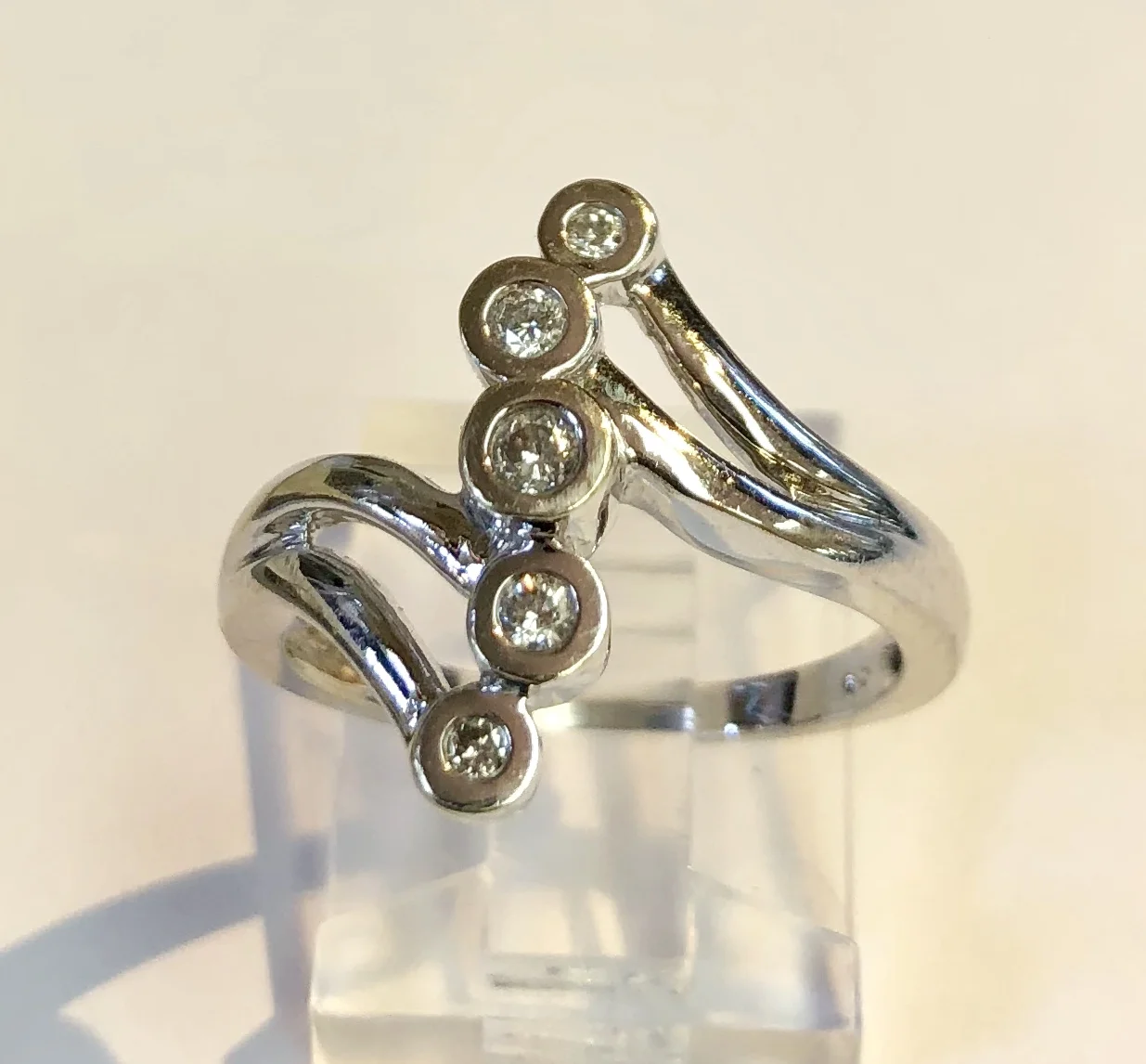 Item no. 233 USD395 Stamped 14k White Gold Diamond Ring. A 'journey' diamond ring with 5 bezel set diamonds of various sizes. A very nice contemporary ring. 4.2 grams