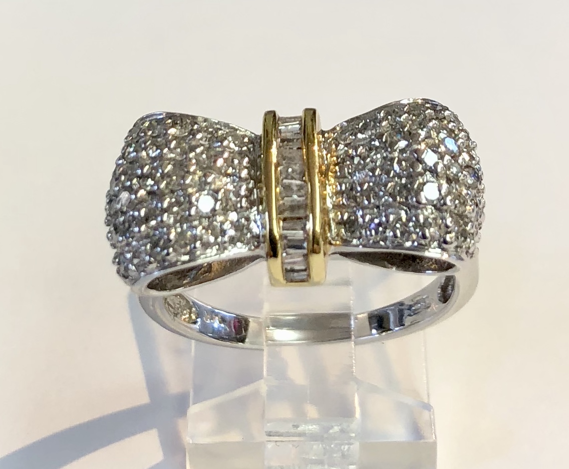 Item No. A15 US$775 14K White and Yellow Gold Diamond Ring. Dressy diamond ring in the shape of a bow, baguettes in the centre, flanked by yellow gold and wonderful pave diamonds. Classic and timeless. 6.1 grams