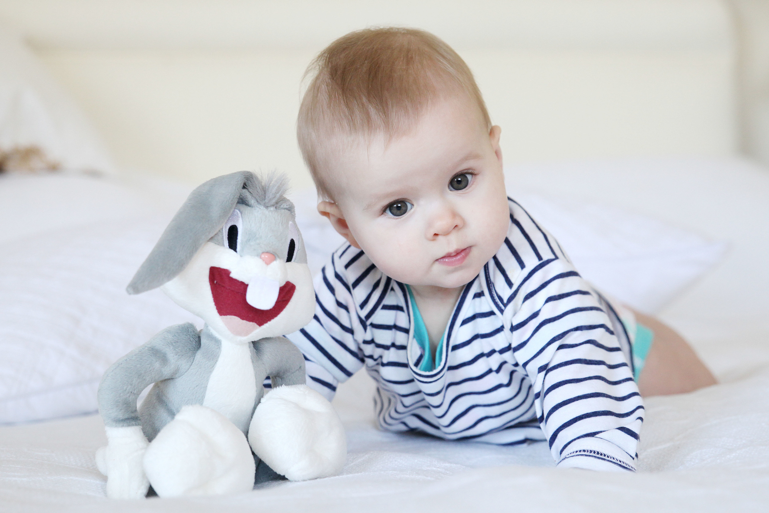 A photo shoot on a bed with natural light streaming through a window on the left