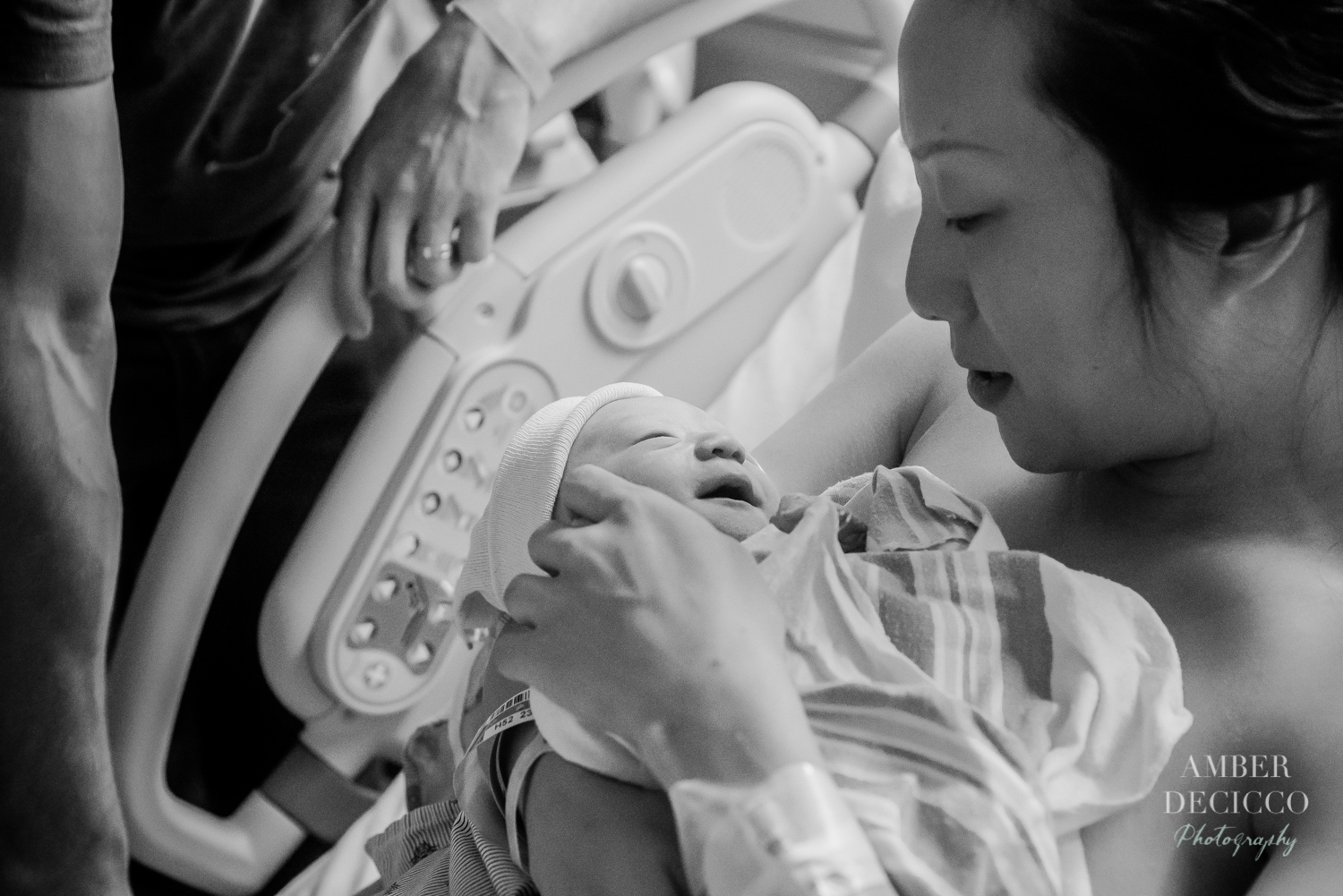 Mom and dad admiring their baby | Birth Photography ©Amber DeCicco Photography